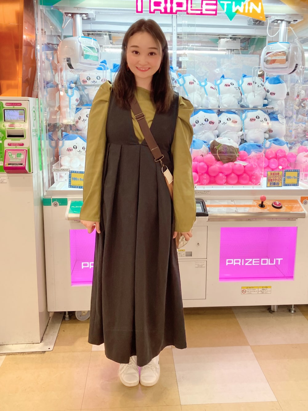 ブラック系のジャンパースカート、グリーン系のシャツ/ブラウス、グリーン系のスニーカーを着用したレディースの秋コーディネートの2枚目の写真