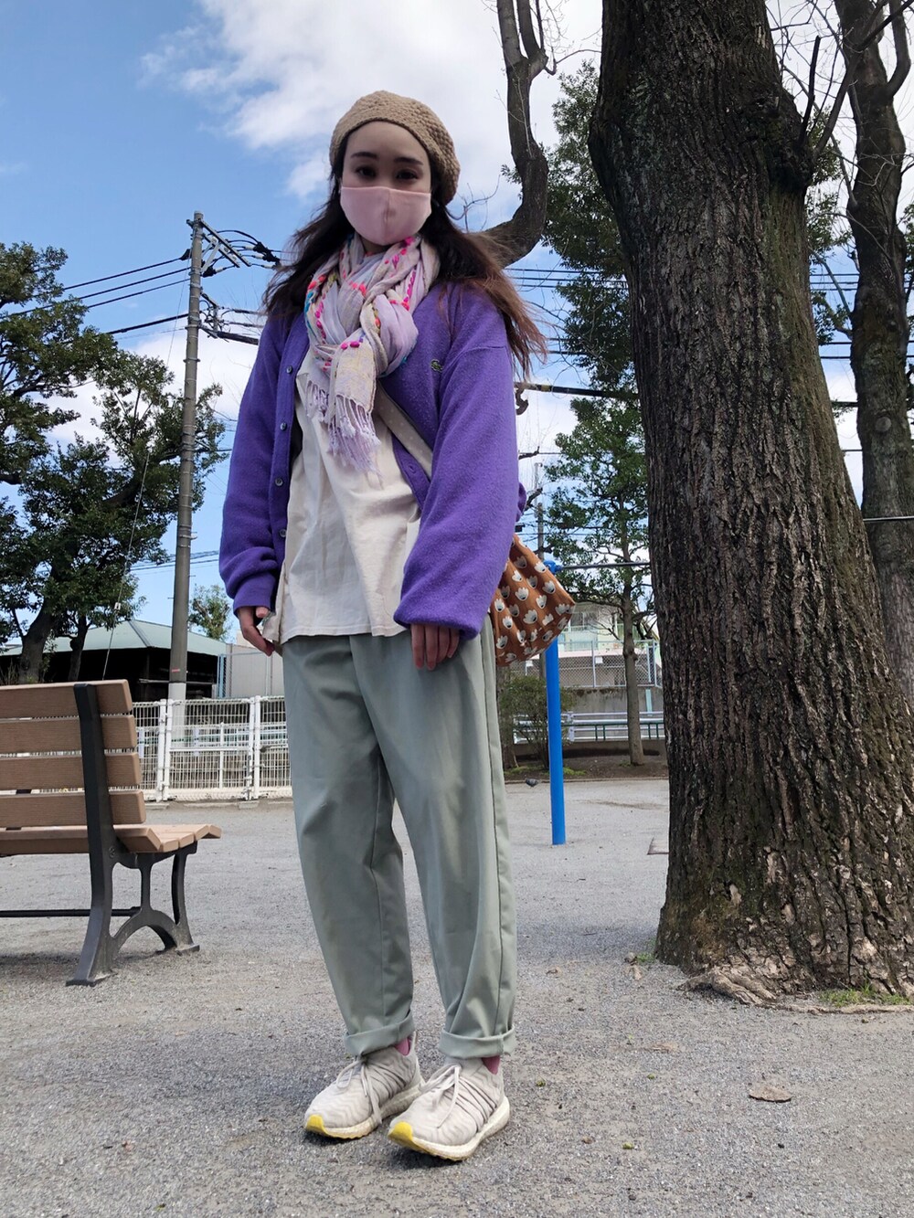 パープル系のカーディガン/ボレロ、ホワイト系のチュニック、グリーン系のパンツを着用したレディースの春コーディネートの4枚目の写真