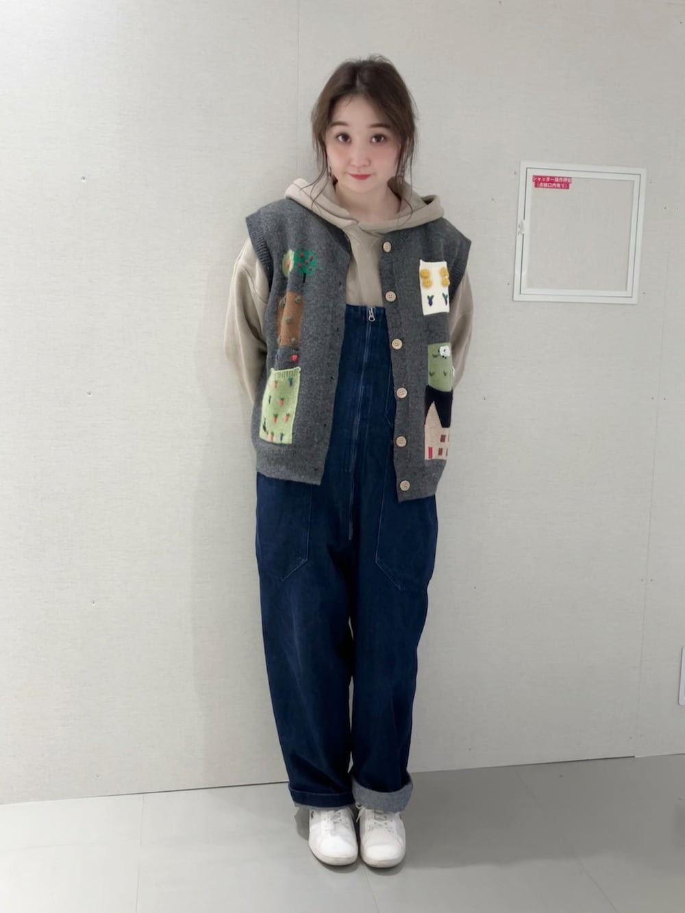 グレー系のベスト、ベージュ系のパーカー、ブルー系のサロペット/オーバーオールを着用したレディースの秋コーディネートの3枚目の写真