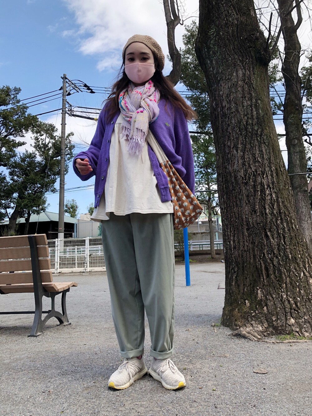 パープル系のカーディガン/ボレロ、ホワイト系のチュニック、グリーン系のパンツを着用したレディースの春コーディネートの3枚目の写真