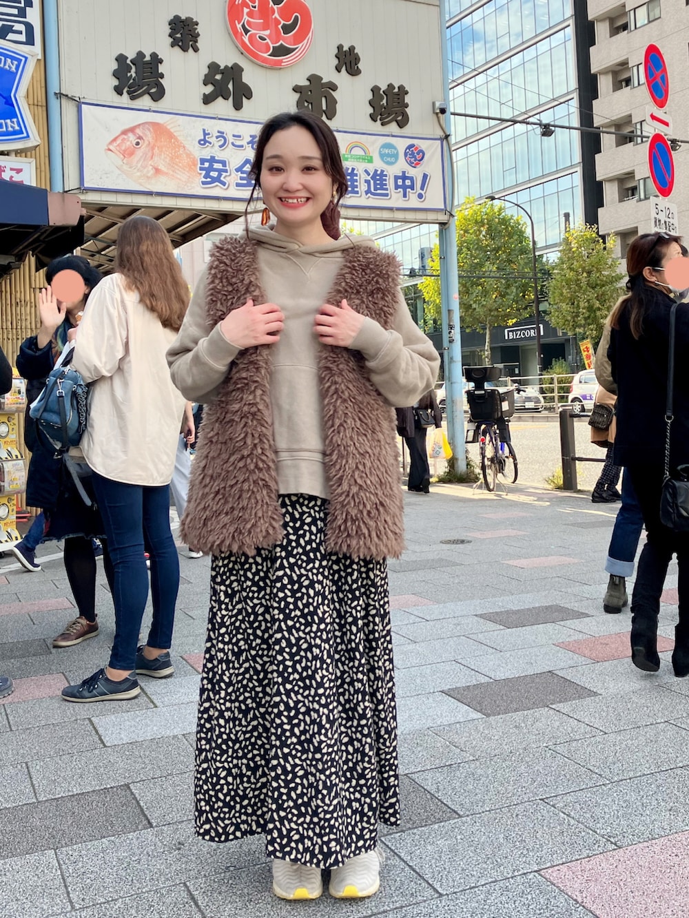 ベージュ系のパーカー、ブラウン系のベスト、ブラック系のスカートを着用したレディースの秋コーディネートの2枚目の写真