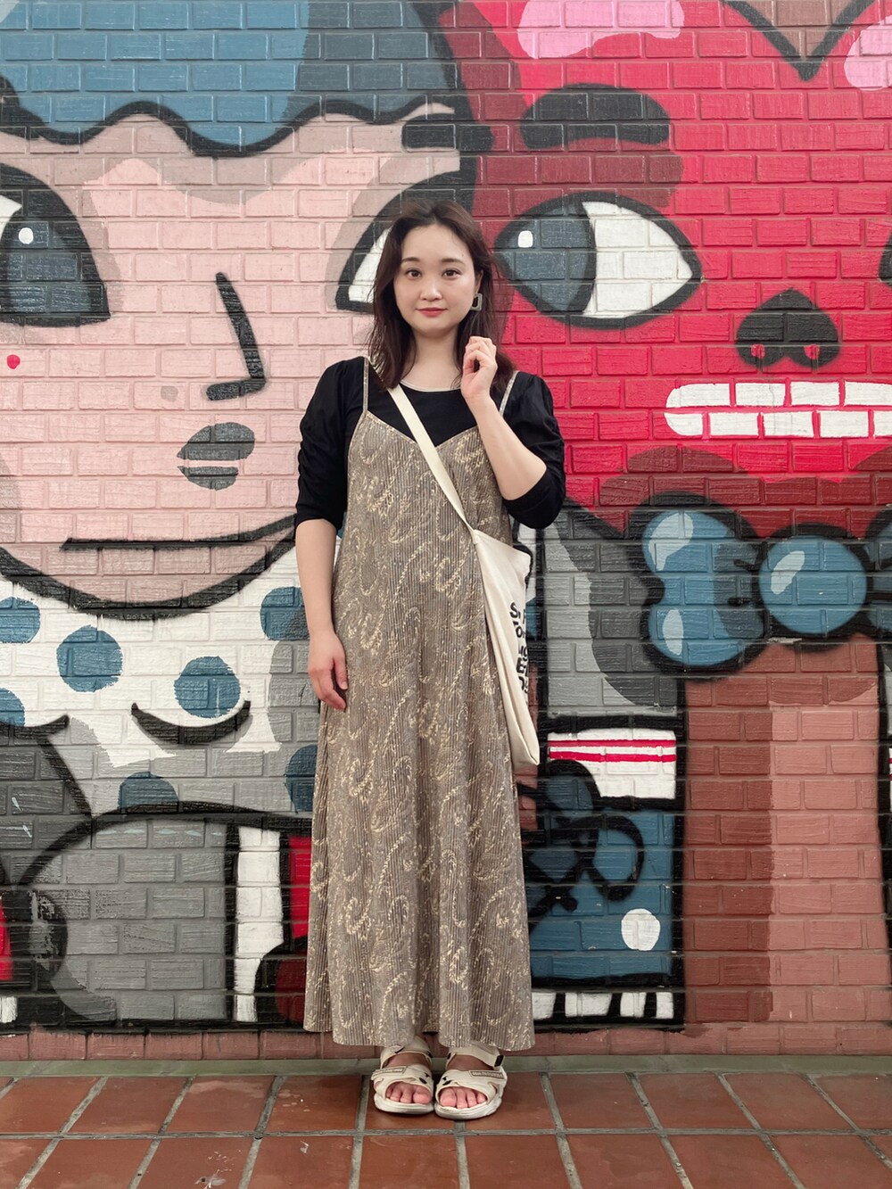 グレー系のワンピース、ブラック系のTシャツ/カットソー、ホワイト系のトートバッグを着用したレディースの秋コーディネートの3枚目の写真