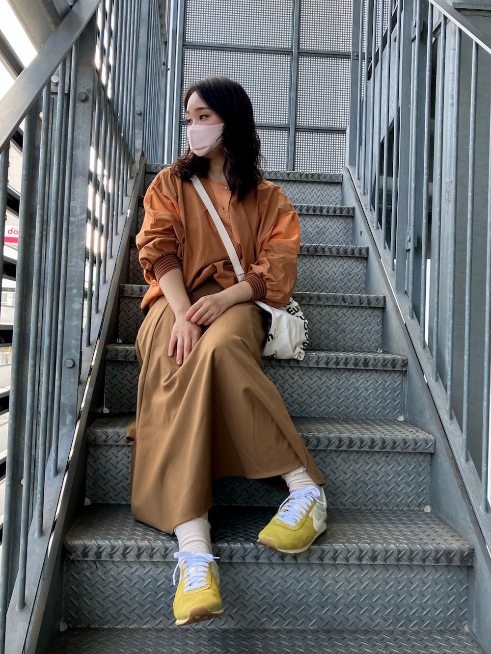 ブラウン系のシャツ/ブラウス、ホワイト系のトートバッグ、ブラウン系のスカートを着用したレディースの秋コーディネートの2枚目の写真