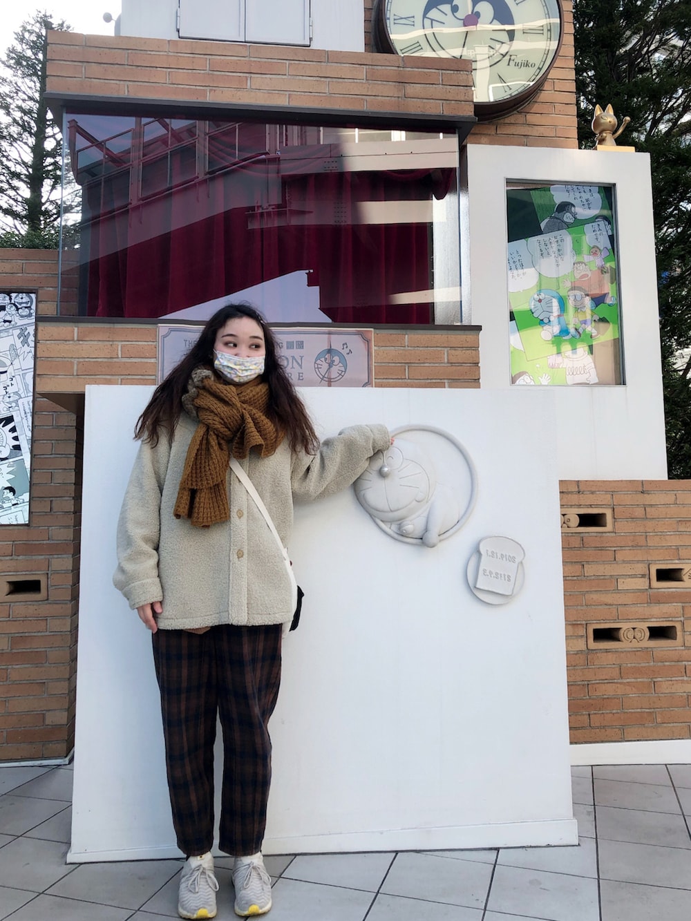 ベージュ系のその他アウター、ブラウン系のパンツ、グレー系のスニーカーを着用したレディースの冬コーディネートの2枚目の写真