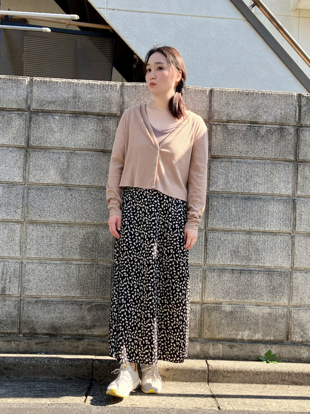 ベージュ系のカーディガン/ボレロ、ブラック系のスカート、グレー系のスニーカーを着用したレディースの秋コーディネートの2枚目の写真
