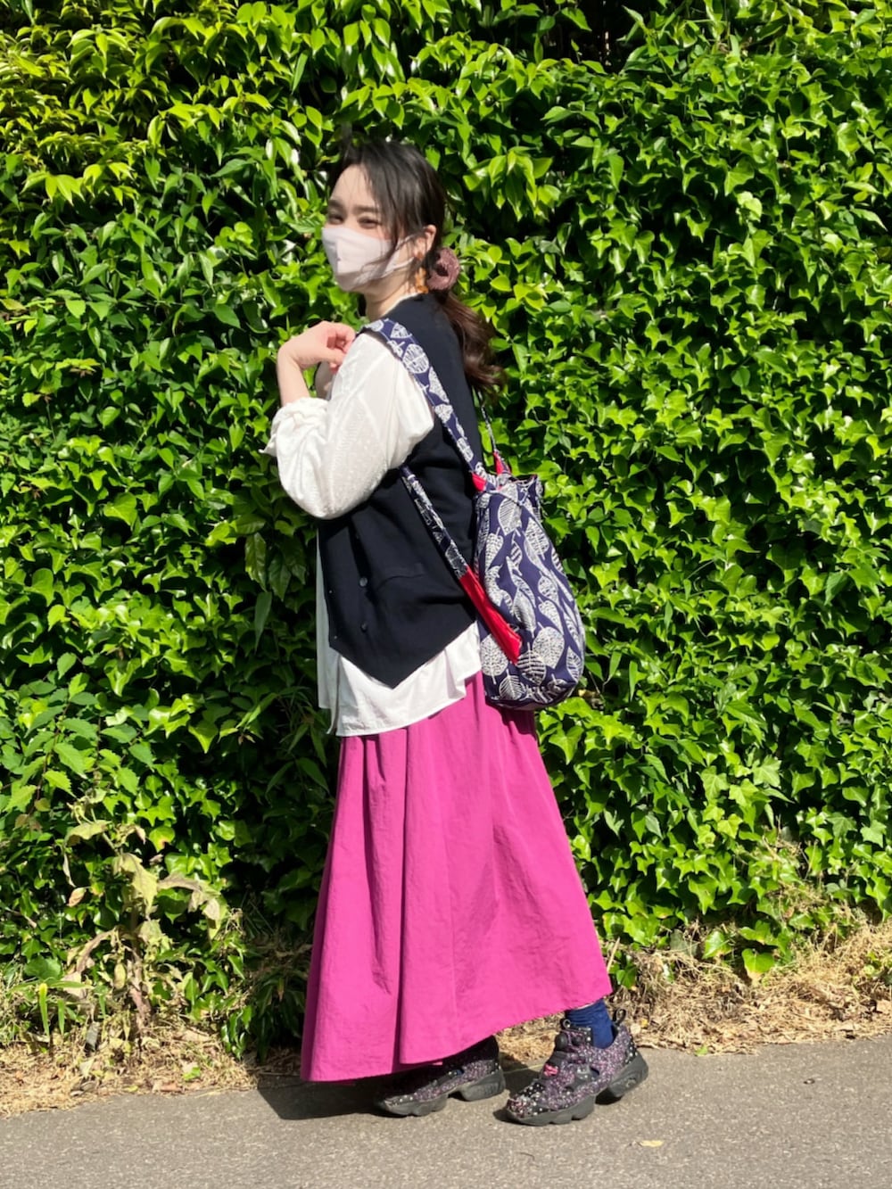 ホワイト系のシャツ/ブラウス、ブルー系のベスト、ピンク系のスカートを着用したレディースの春コーディネートの5枚目の写真