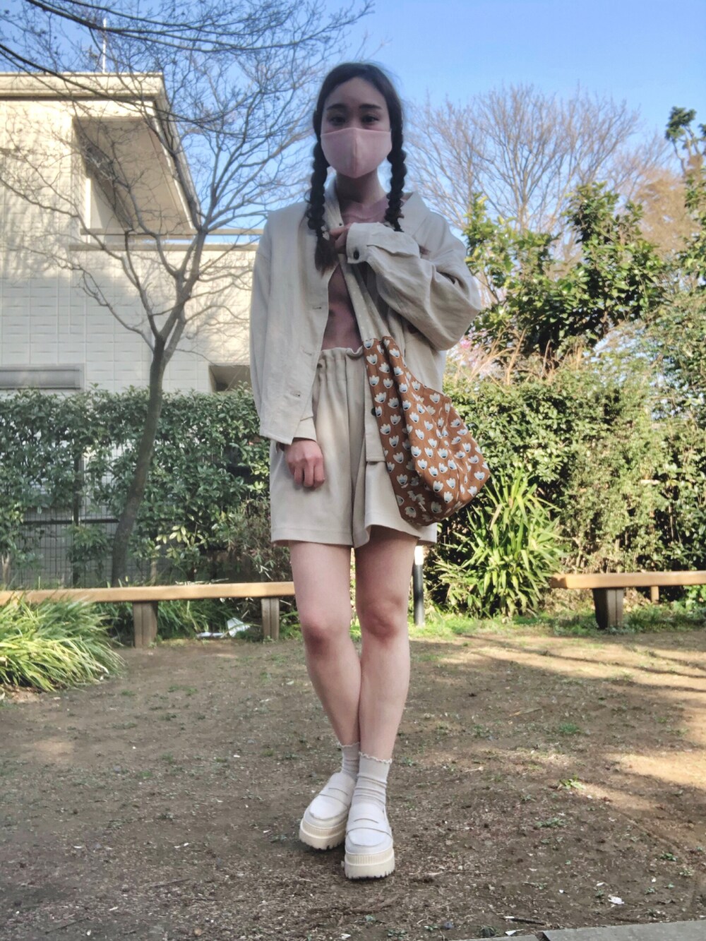 ブラウン系のショルダーバッグ、ホワイト系のミリタリージャケット、ピンク系のTシャツ/カットソーを着用したレディースの春コーディネートの3枚目の写真