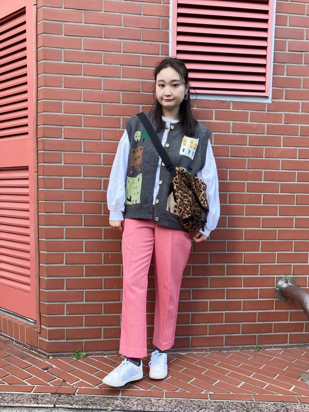 ピンク系のパンツ、ブラウン系のメッセンジャーバッグ、ホワイト系のTシャツ/カットソーを着用したレディースの秋コーディネートの4枚目の写真