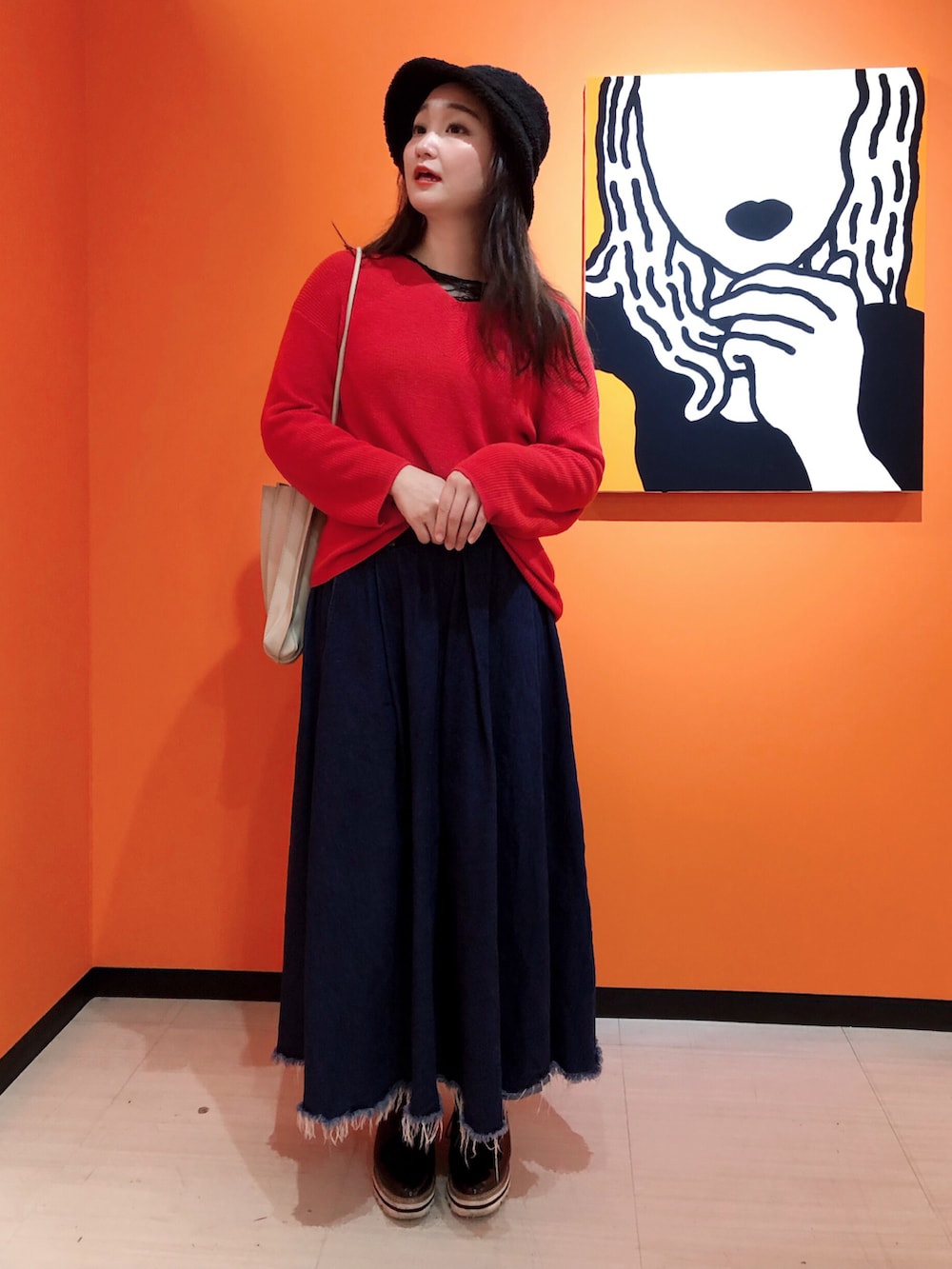 ブルー系のデニムスカート、ブラック系のその他シューズ、レッド系のニット/セーターを着用したレディースの冬コーディネートの2枚目の写真