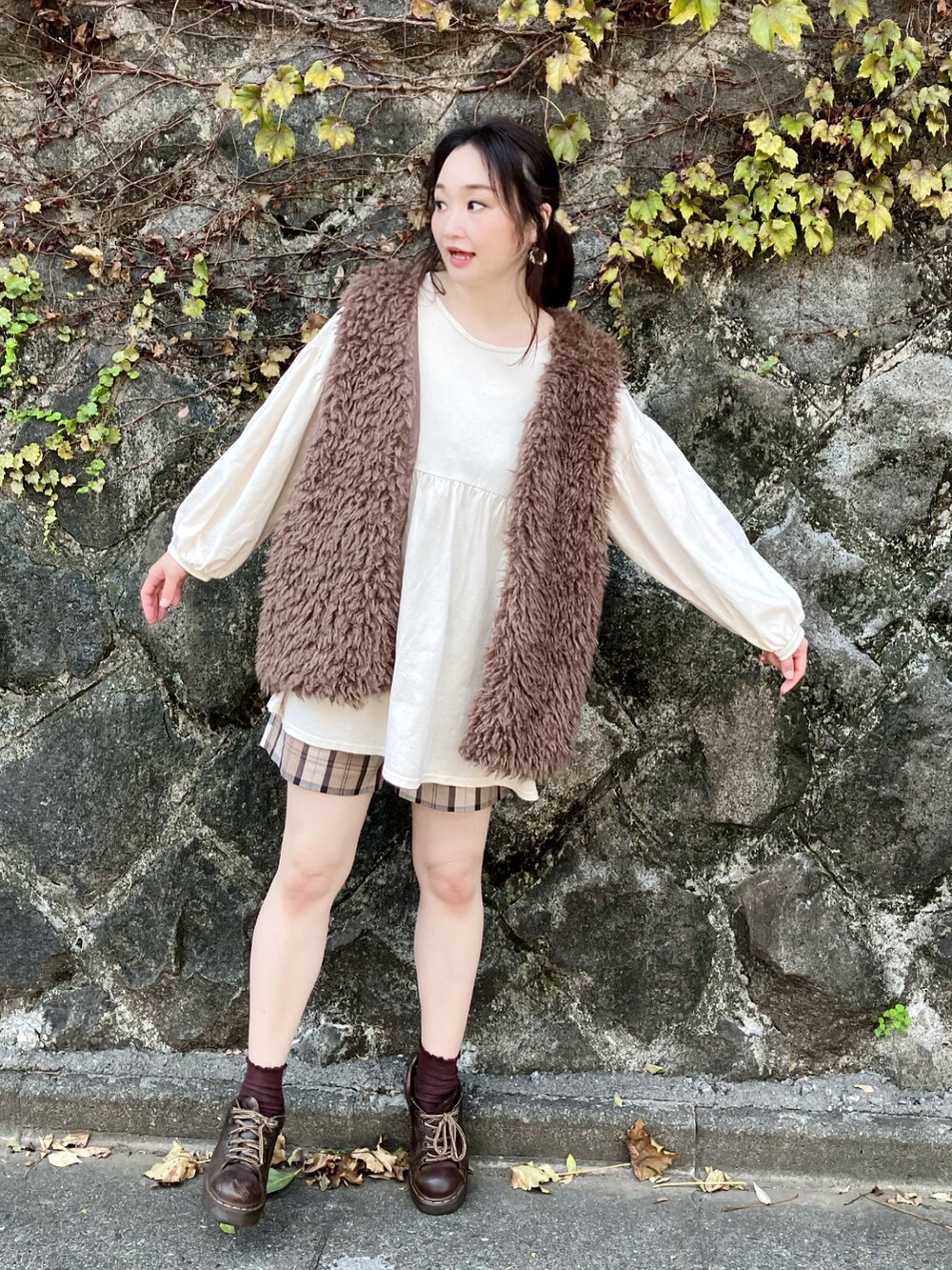 ブラウン系のベスト、ホワイト系のチュニック、ブラウン系のその他パンツを着用したレディースの秋コーディネートの4枚目の写真