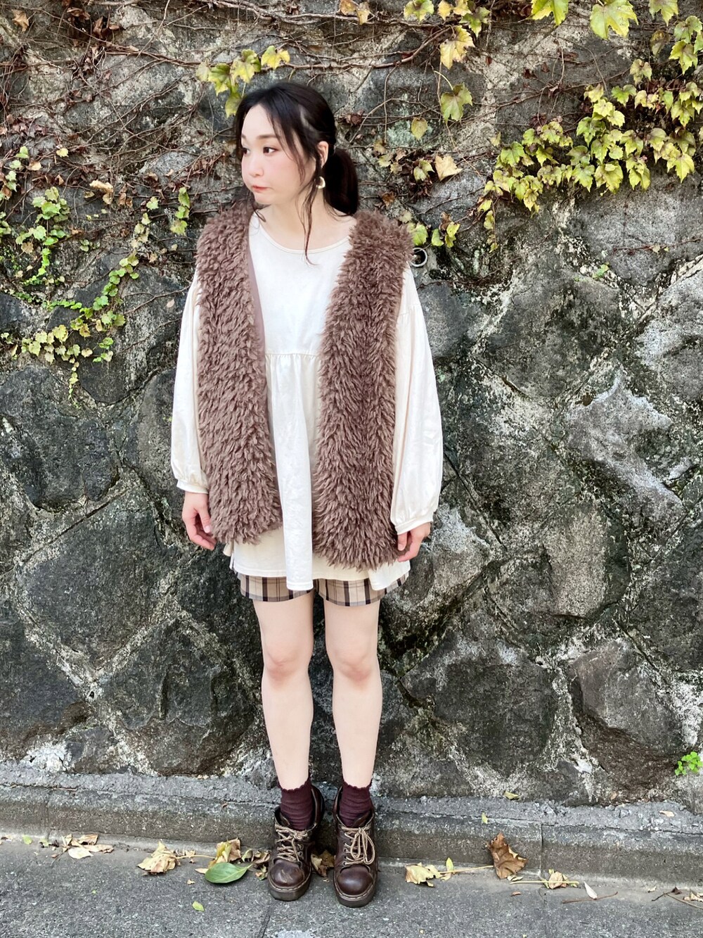 ブラウン系のベスト、ホワイト系のチュニック、ブラウン系のその他パンツを着用したレディースの秋コーディネートの5枚目の写真