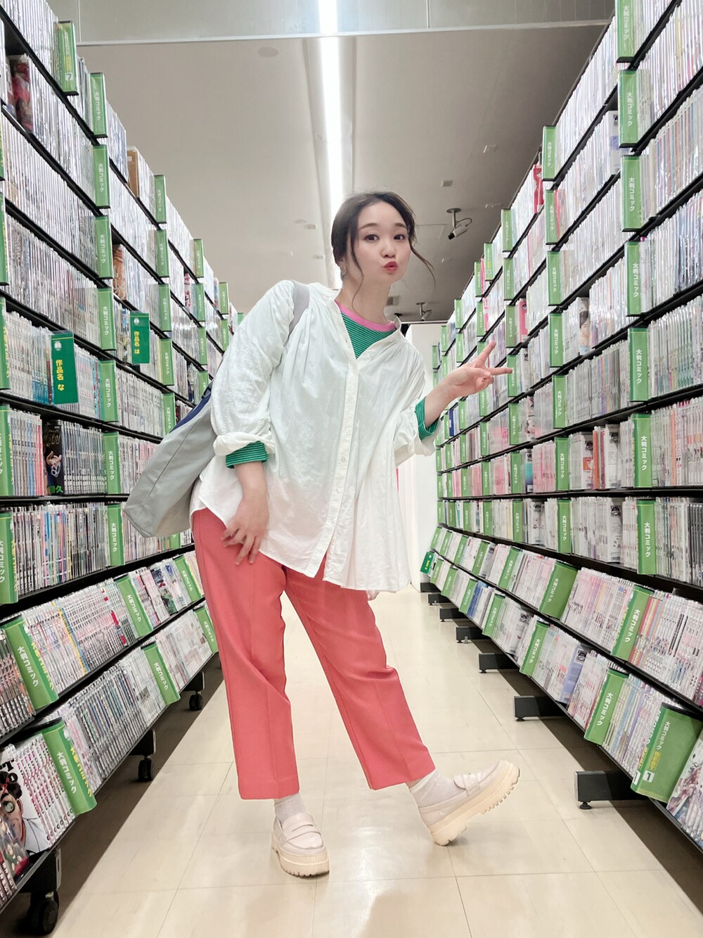 ピンク系のパンツ、グリーン系のTシャツ/カットソー、ホワイト系のローファーを着用したレディースの秋コーディネートの2枚目の写真