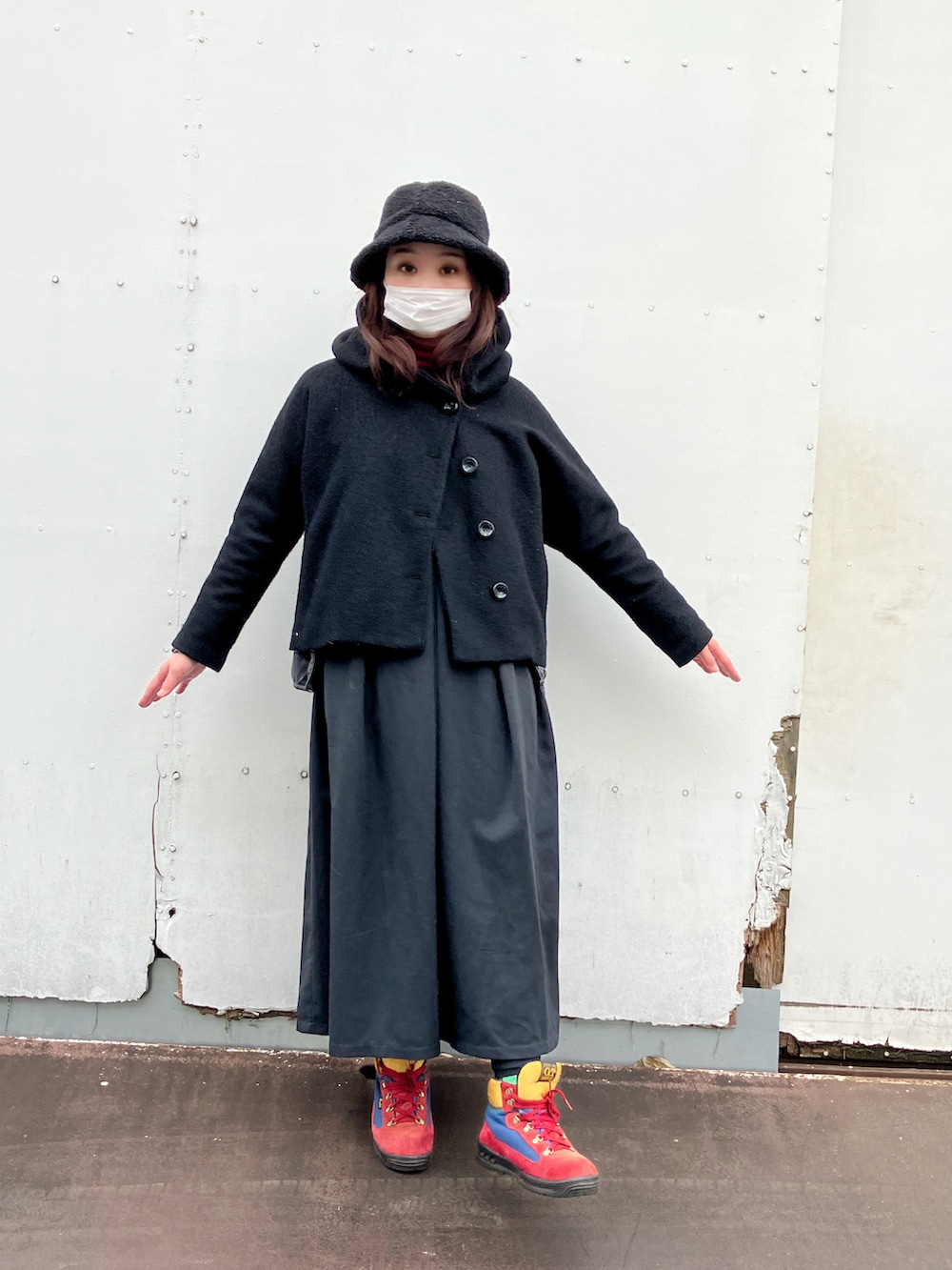 ブラック系のジャケット/アウター、ブラック系のジャンパースカート、グレー系のダウンジャケット/コートを着用したレディースの冬コーディネートの2枚目の写真