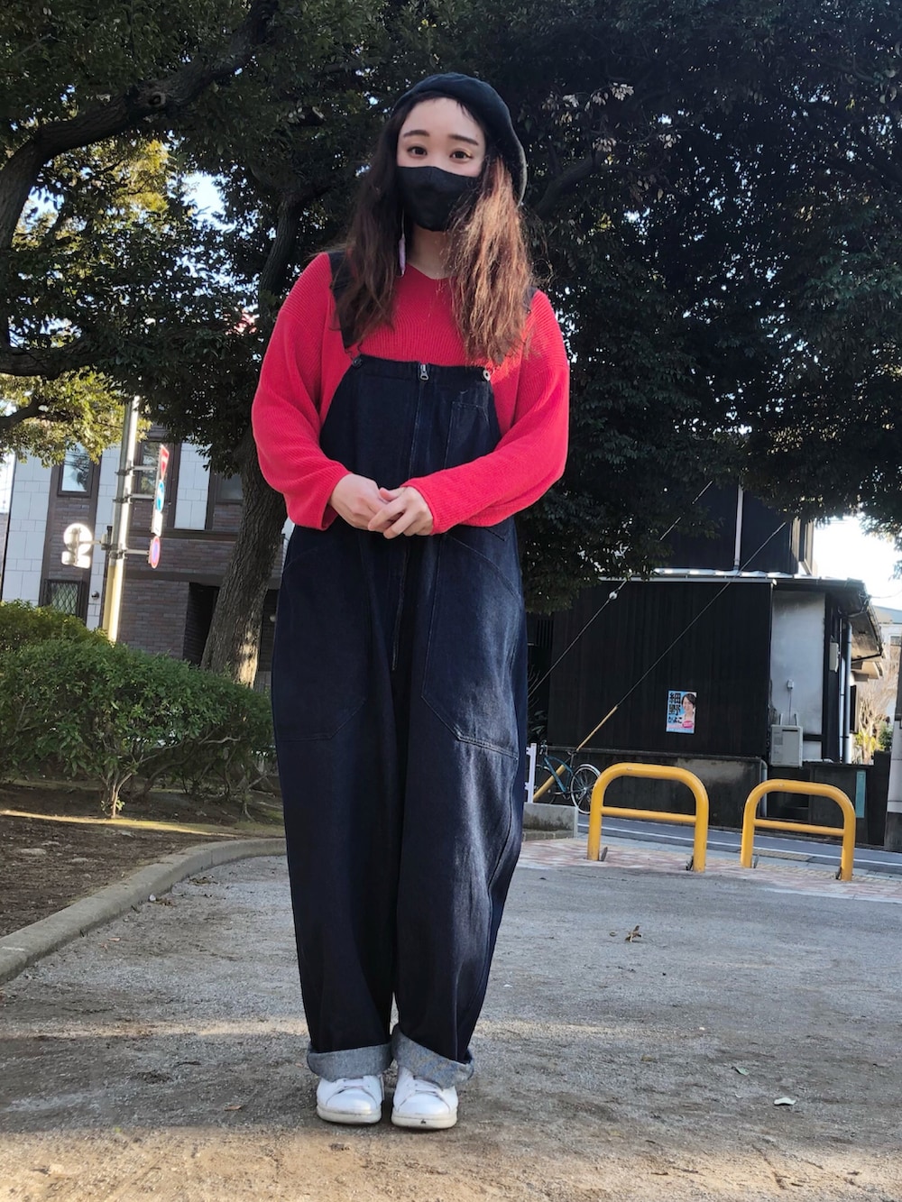 レッド系のニット/セーター、ブルー系のサロペット/オーバーオール、ホワイト系のスニーカーを着用したレディースの春コーディネートの2枚目の写真