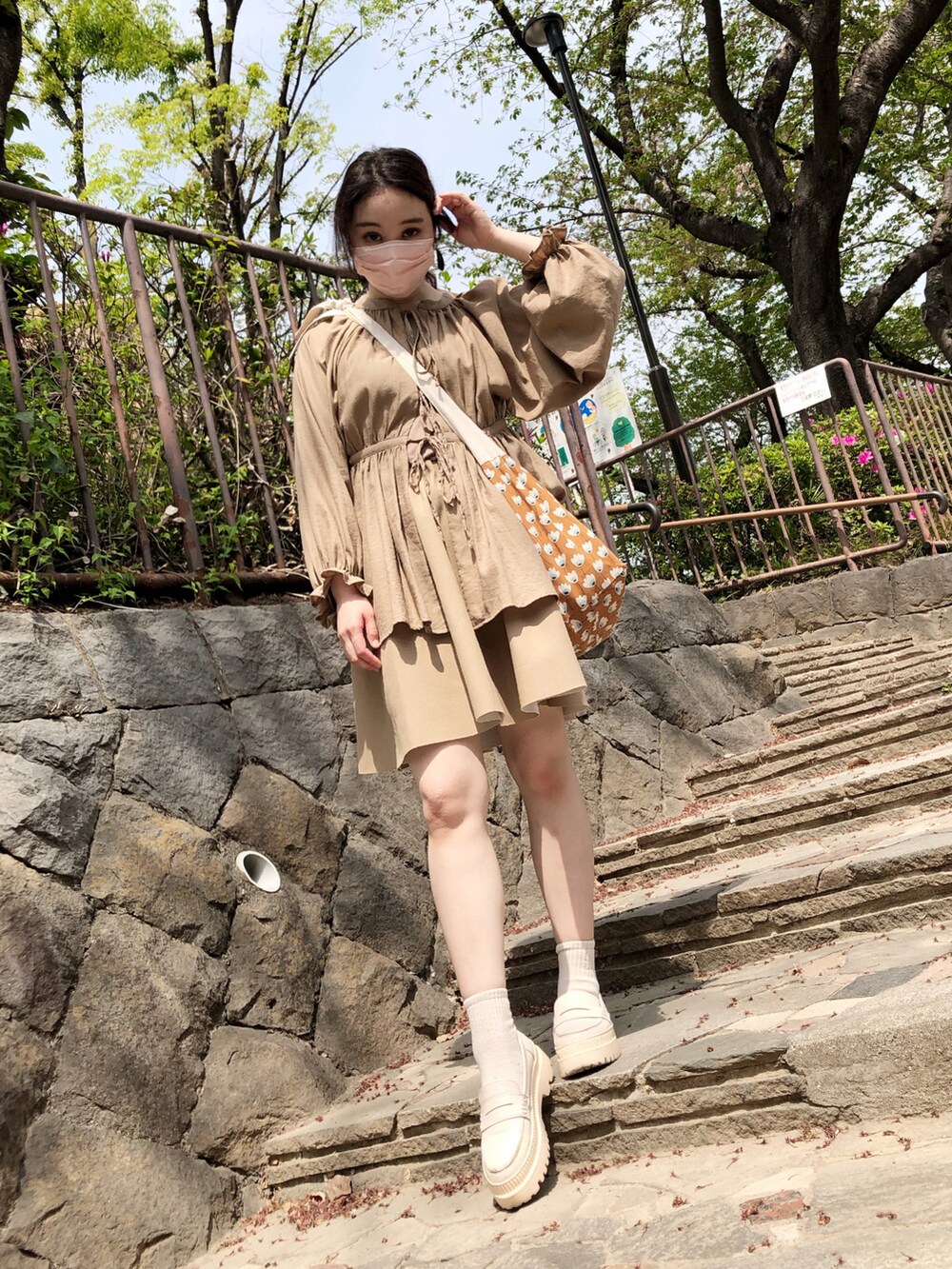 ブラウン系のシャツ/ブラウス、ブラウン系のショルダーバッグ、ベージュ系のスカートを着用したレディースの春コーディネートの2枚目の写真