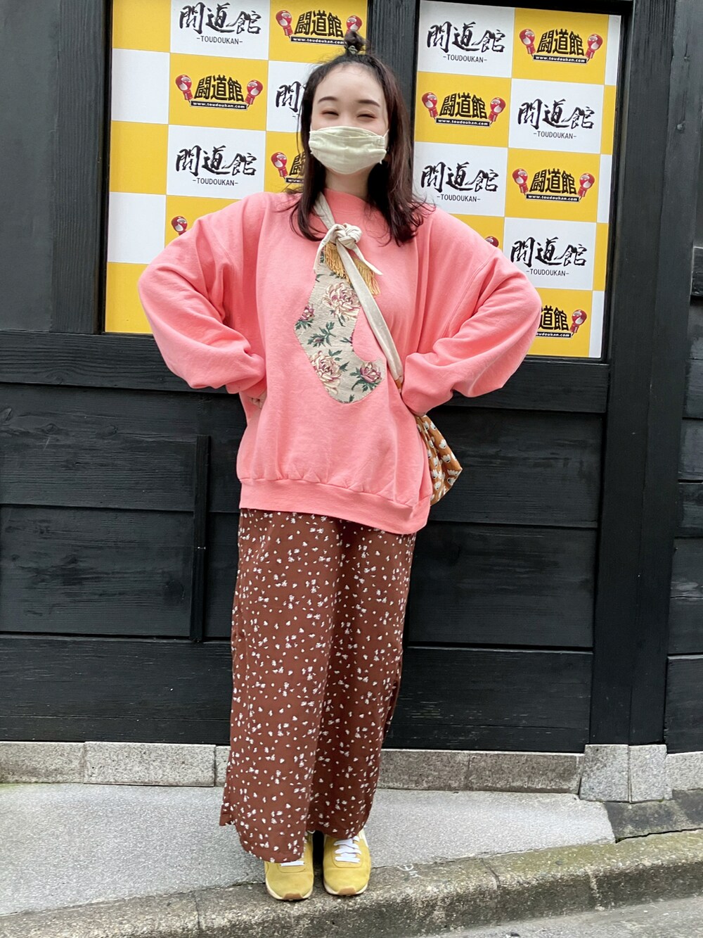 ピンク系のスウェット、ブラウン系のセットアップ、イエロー系のスニーカーを着用したレディースの秋コーディネートの2枚目の写真