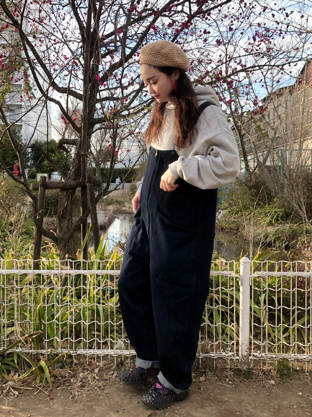 グレー系のパーカー、ブルー系のサロペット/オーバーオール、ホワイト系のミリタリージャケットを着用したレディースの春コーディネートの3枚目の写真