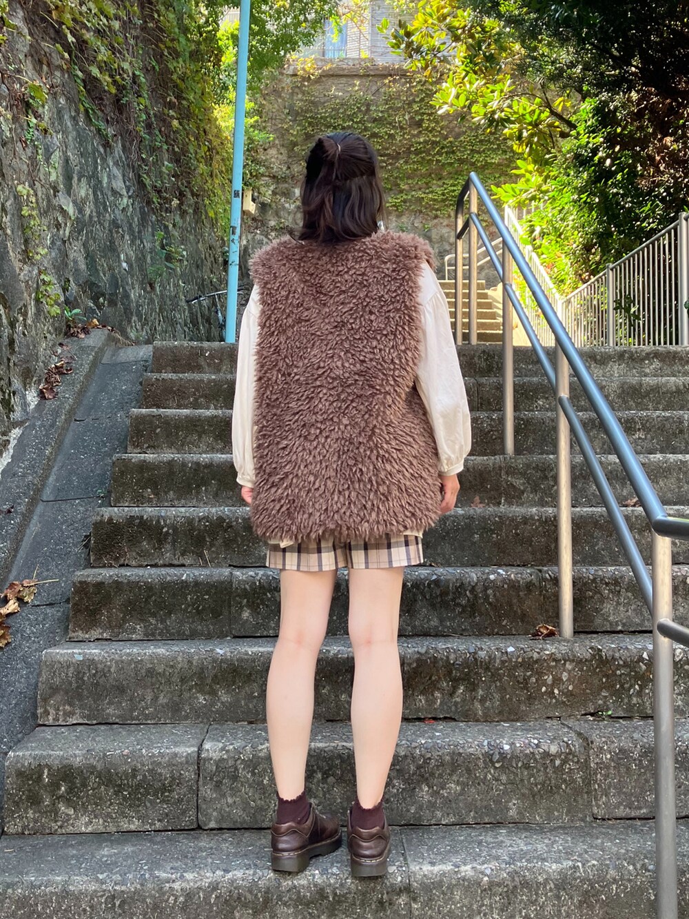 ブラウン系のベスト、ホワイト系のチュニック、ブラウン系のその他パンツを着用したレディースの秋コーディネートの2枚目の写真