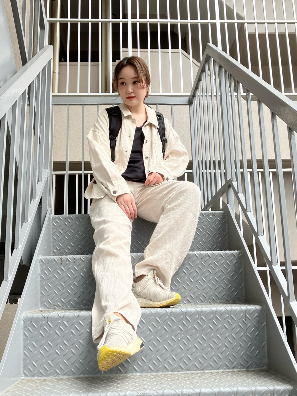 ホワイト系のミリタリージャケット、ホワイト系のその他パンツ、グレー系のスニーカーを着用したレディースの春コーディネートの3枚目の写真