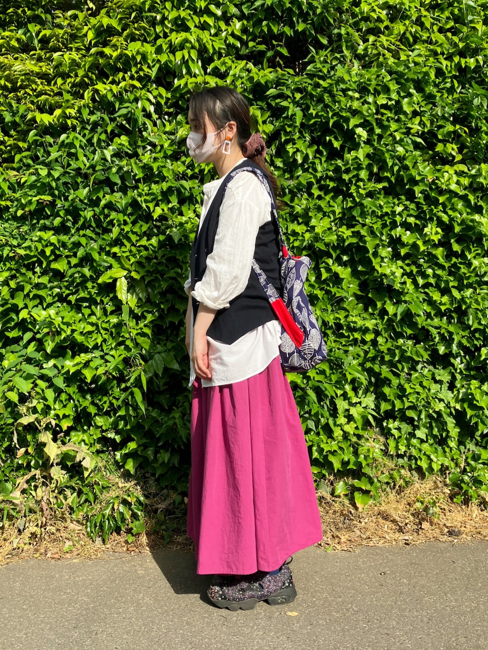 ホワイト系のシャツ/ブラウス、ブルー系のベスト、ピンク系のスカートを着用したレディースの春コーディネートの4枚目の写真