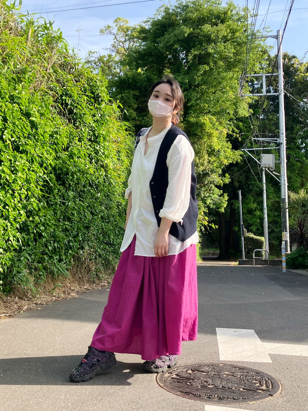 ホワイト系のシャツ/ブラウス、ブルー系のベスト、ピンク系のスカートを着用したレディースの春コーディネートの2枚目の写真