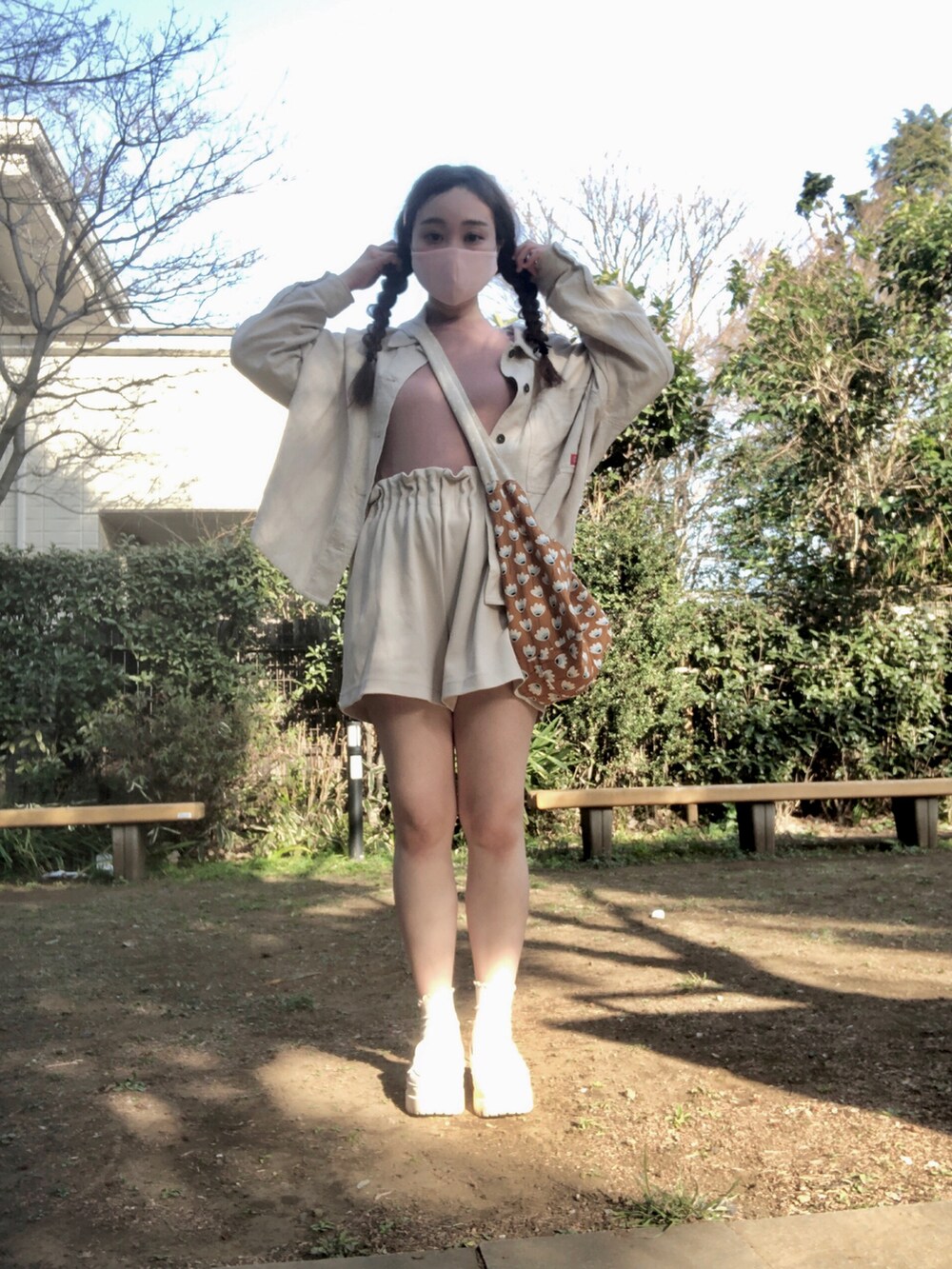 ブラウン系のショルダーバッグ、ホワイト系のミリタリージャケット、ピンク系のTシャツ/カットソーを着用したレディースの春コーディネートの4枚目の写真