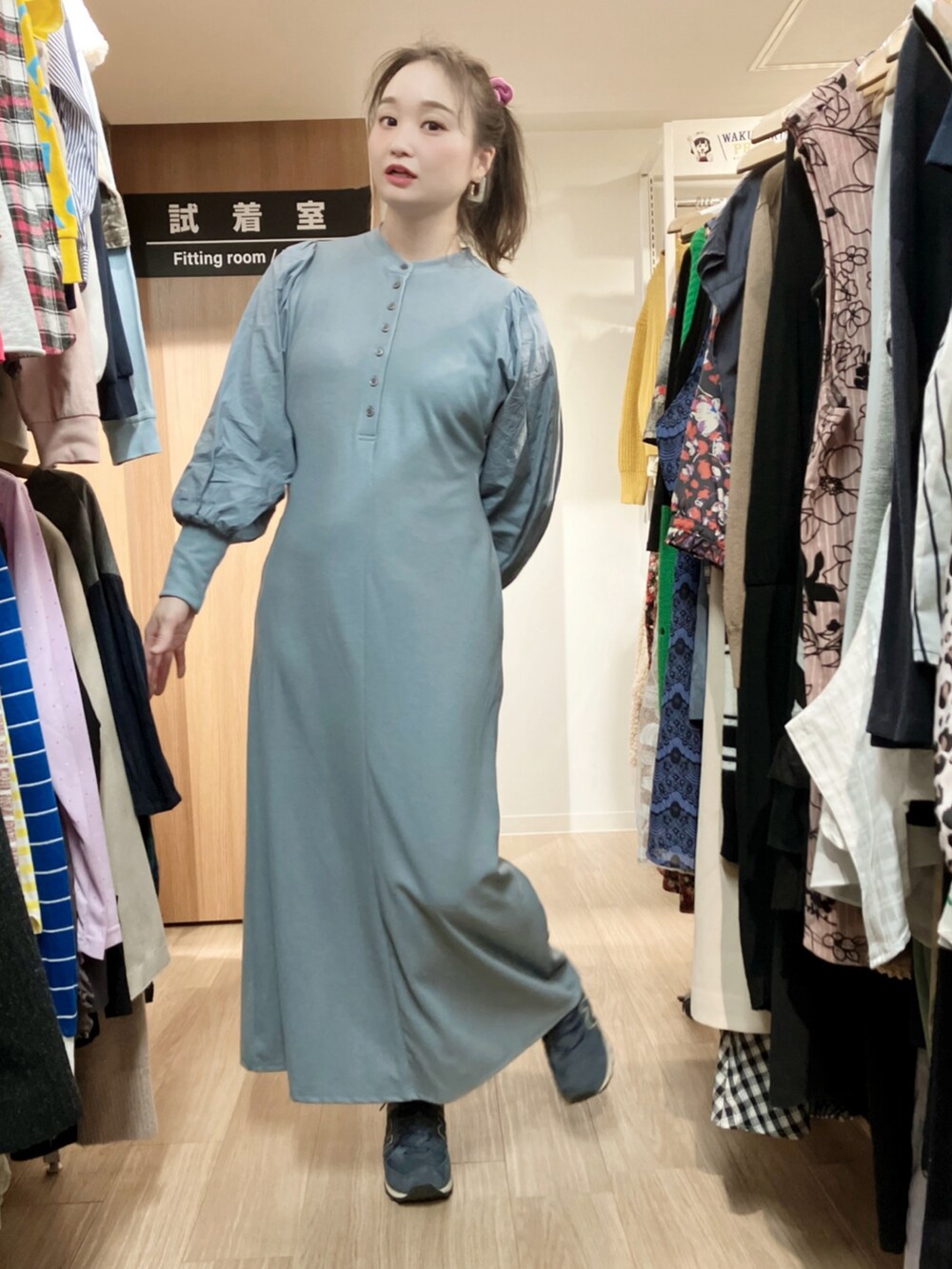 ブルー系のデニムジャケット、ブルー系のワンピース、ブラウン系のショルダーバッグを着用したレディースの秋コーディネートの2枚目の写真