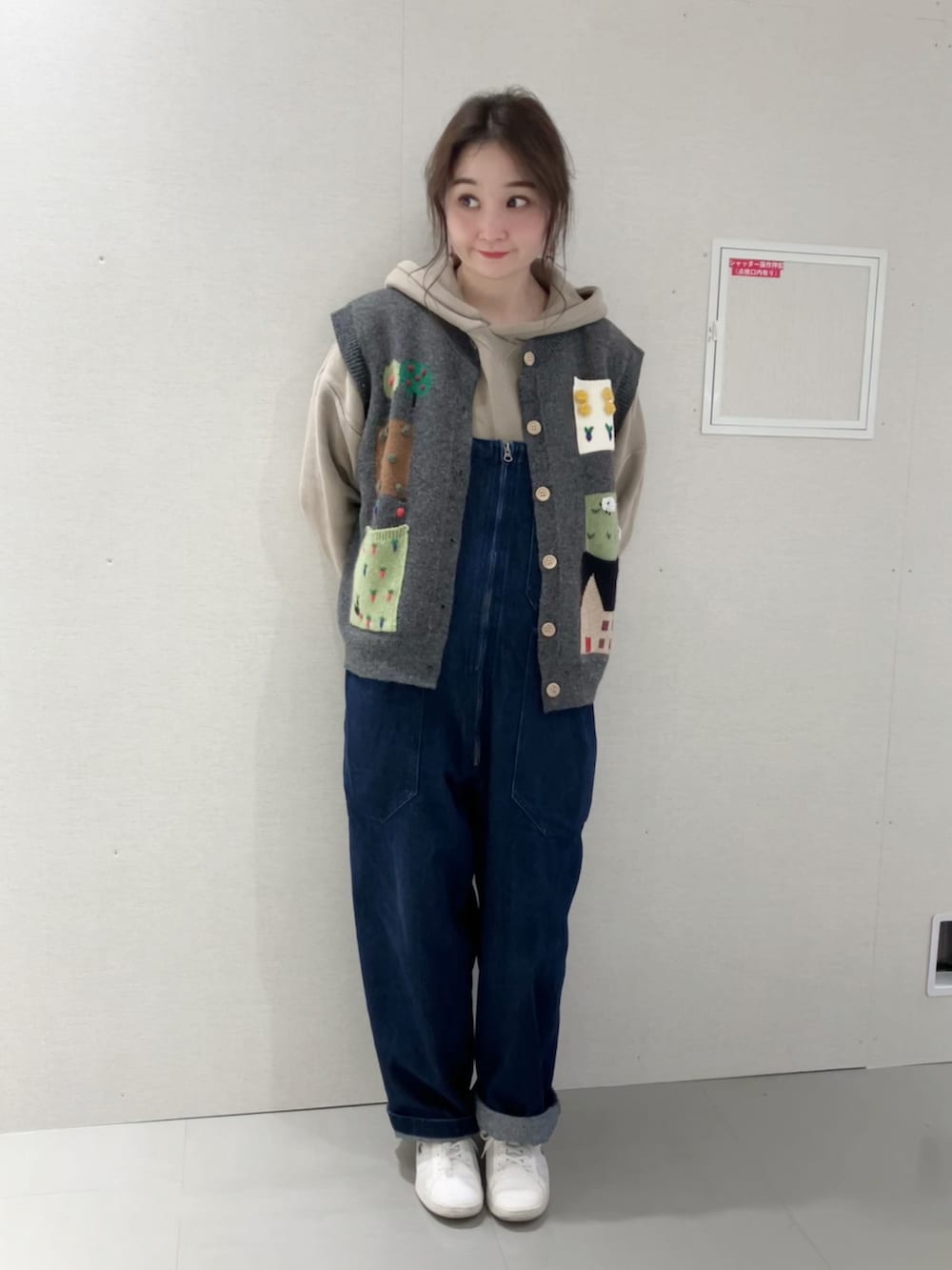 グレー系のベスト、ベージュ系のパーカー、ブルー系のサロペット/オーバーオールを着用したレディースの秋コーディネートの2枚目の写真