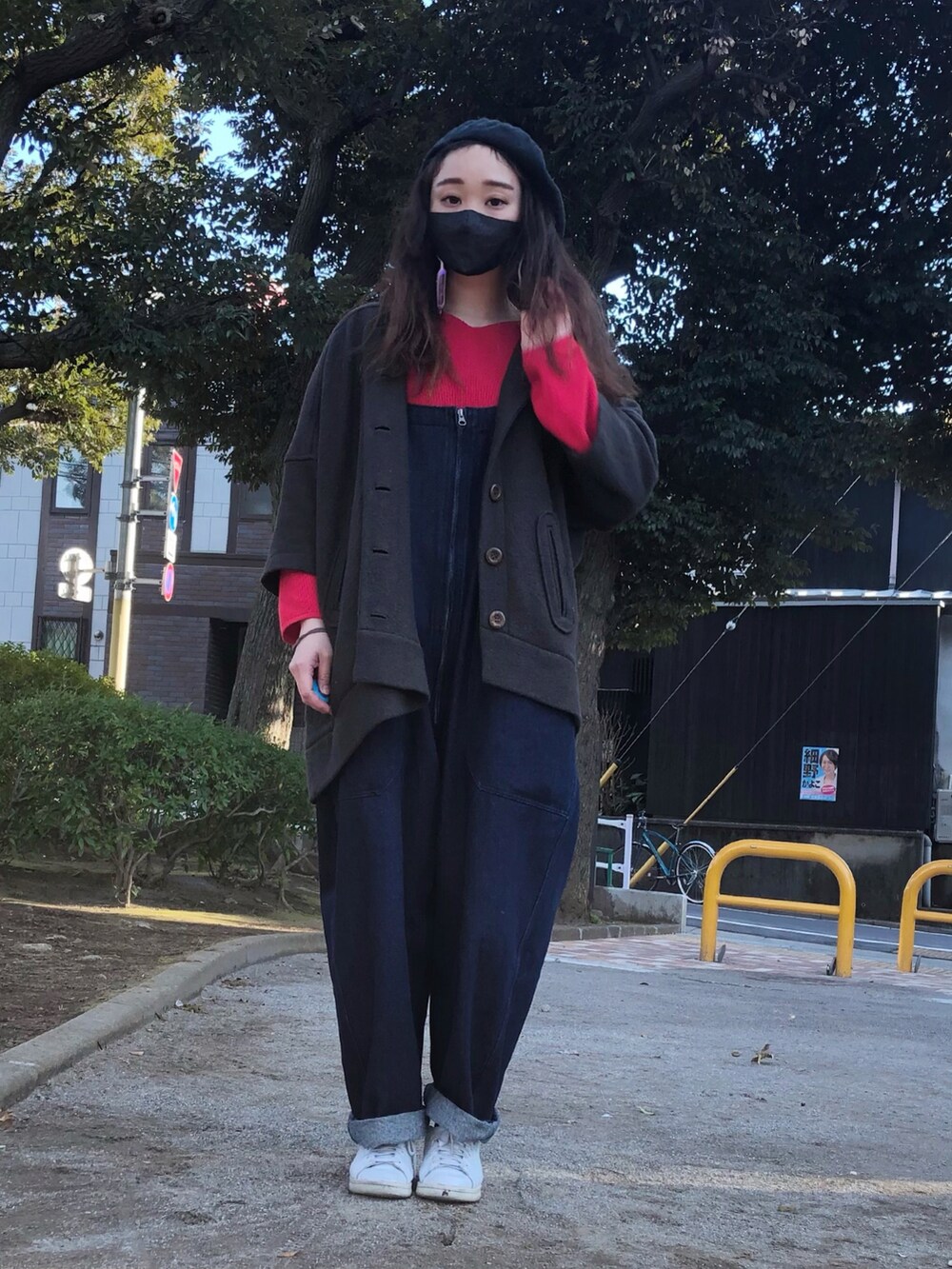 レッド系のニット/セーター、ブルー系のサロペット/オーバーオール、ホワイト系のスニーカーを着用したレディースの春コーディネートの3枚目の写真