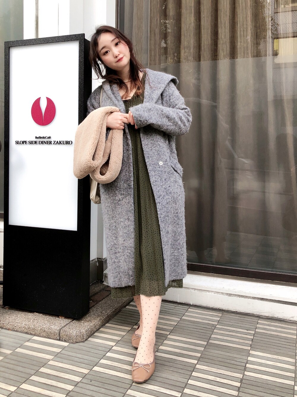 グリーン系のワンピース、グレー系のジャケット/アウター、ブラウン系のバレエシューズを着用したレディースの冬コーディネートの2枚目の写真
