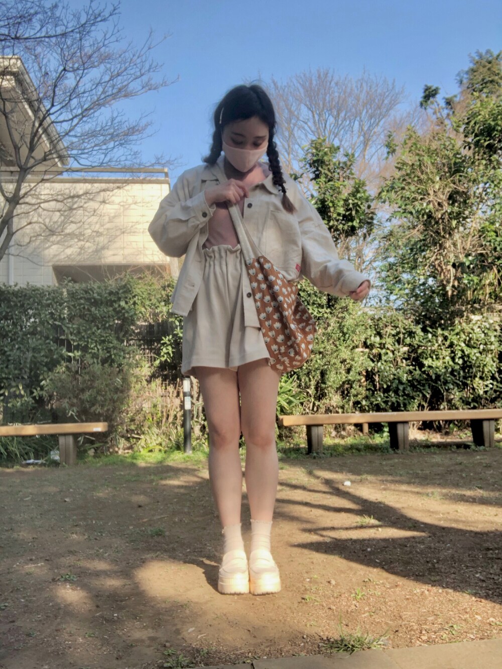 ブラウン系のショルダーバッグ、ホワイト系のミリタリージャケット、ピンク系のTシャツ/カットソーを着用したレディースの春コーディネートの5枚目の写真