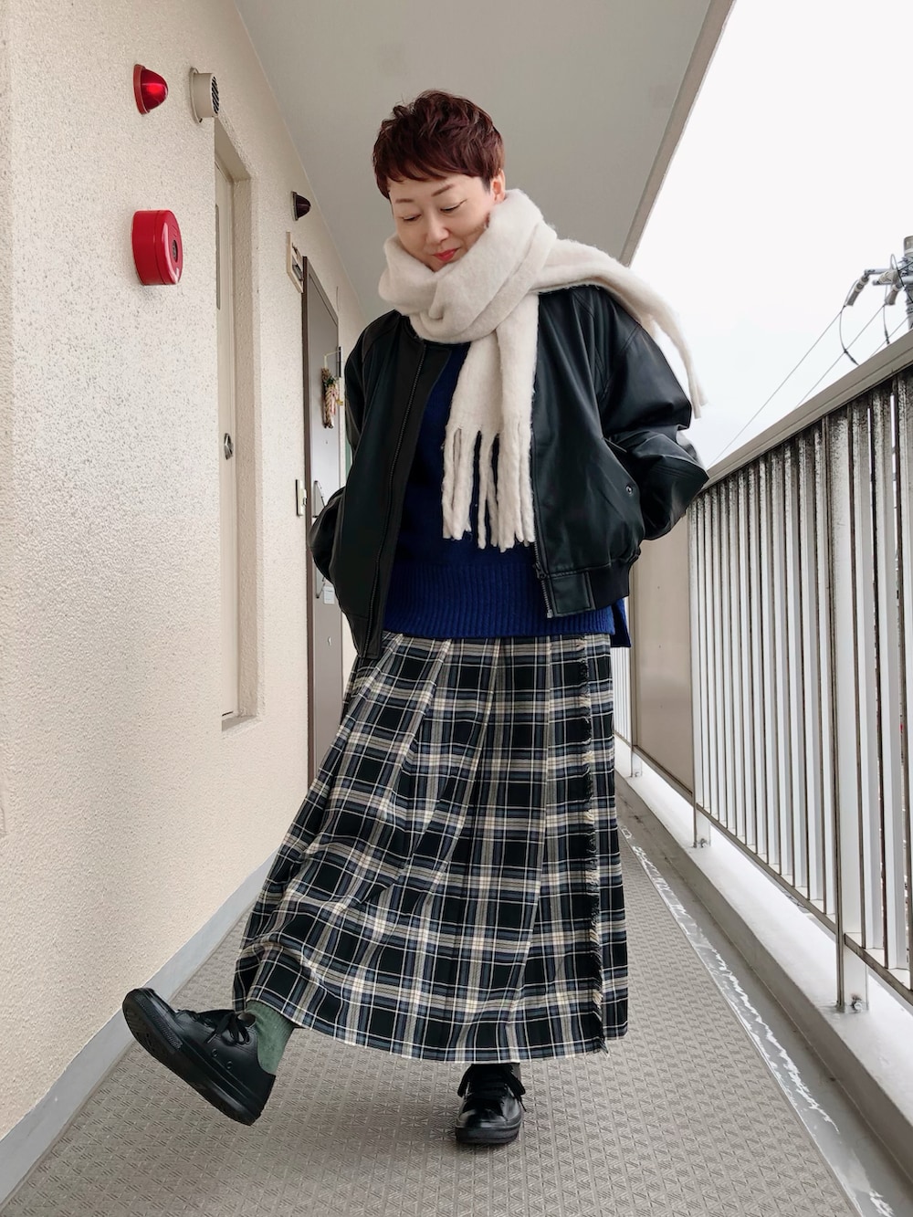 ブラック系のその他アウター、ブルー系のニット/セーター、ブラック系のスカートを着用したレディースの冬コーディネートの2枚目の写真