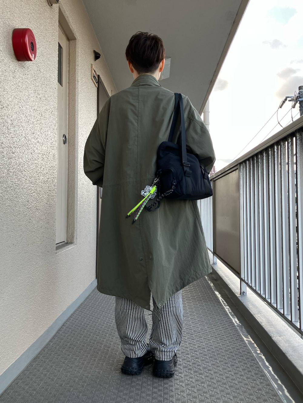 グリーン系のモッズコート、ブルー系のシャツ/ブラウス、イエロー系のスウェットを着用したレディースの冬コーディネートの3枚目の写真