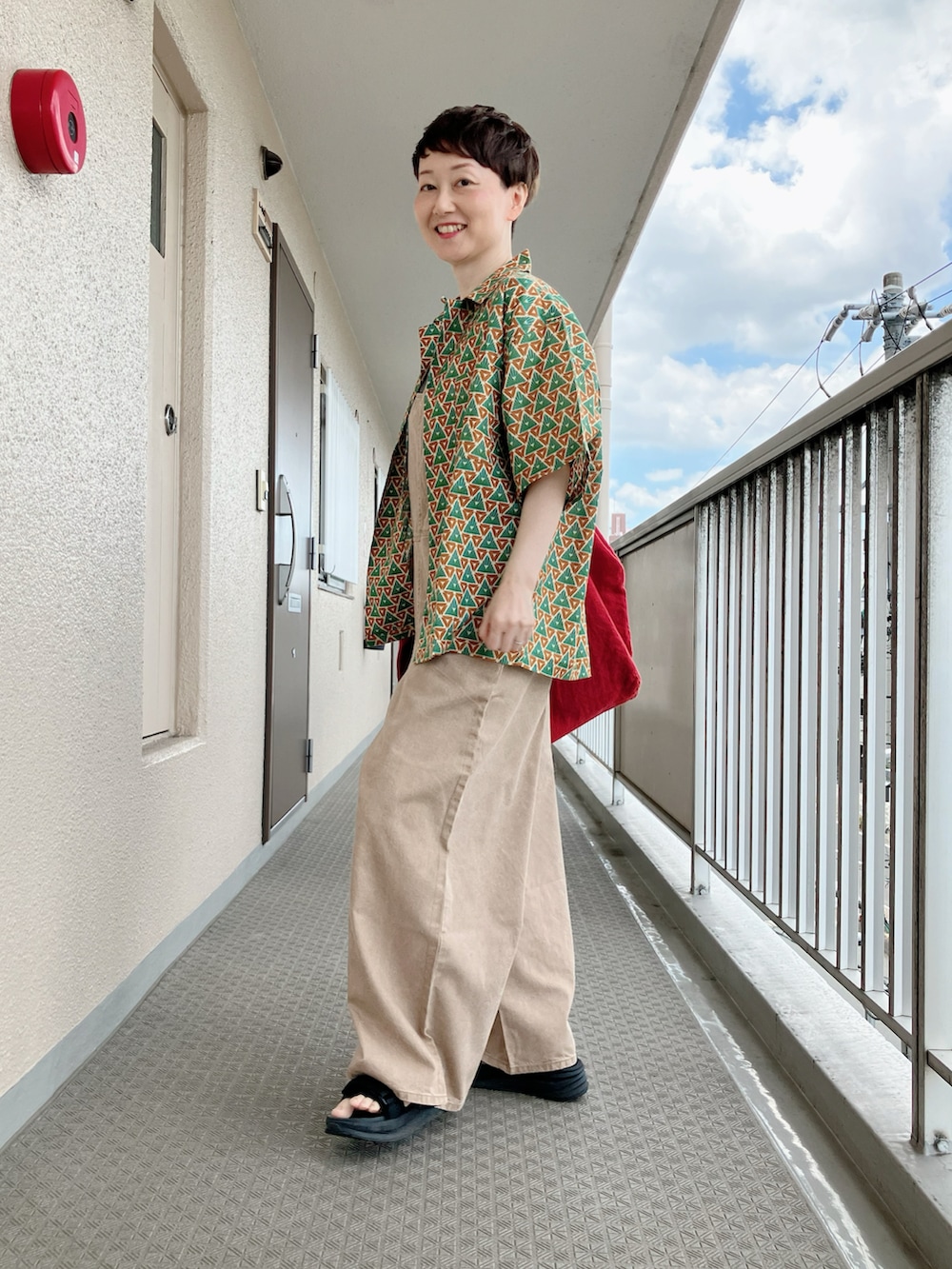 グリーン系のシャツ/ブラウス、ベージュ系のサロペット/オーバーオール、ベージュ系のTシャツ/カットソーを着用したレディースの夏コーディネートの2枚目の写真