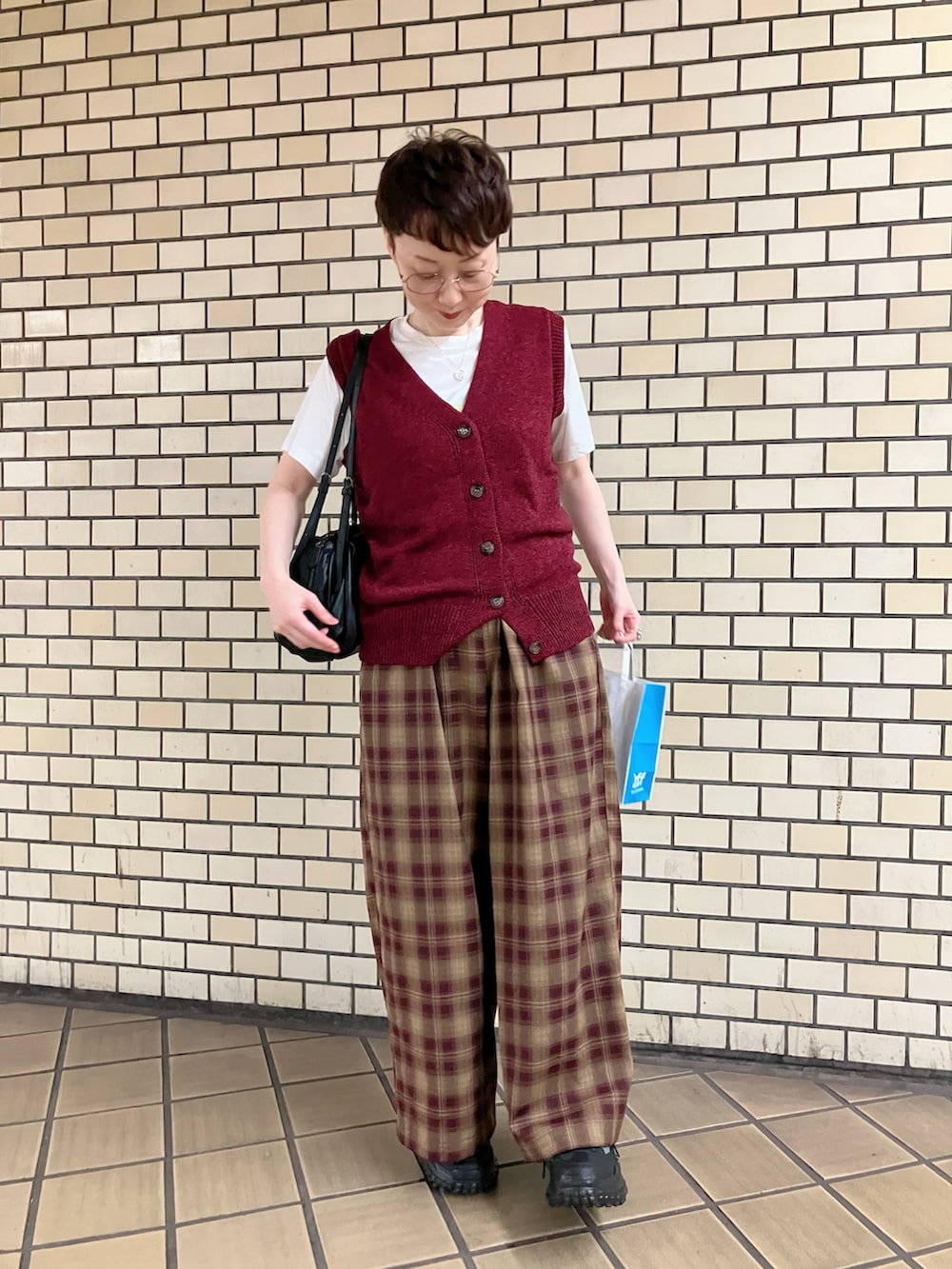 ブラウン系のその他パンツ、ブラック系のボストンバッグ、レッド系のトップスを着用したレディースの秋コーディネートの2枚目の写真