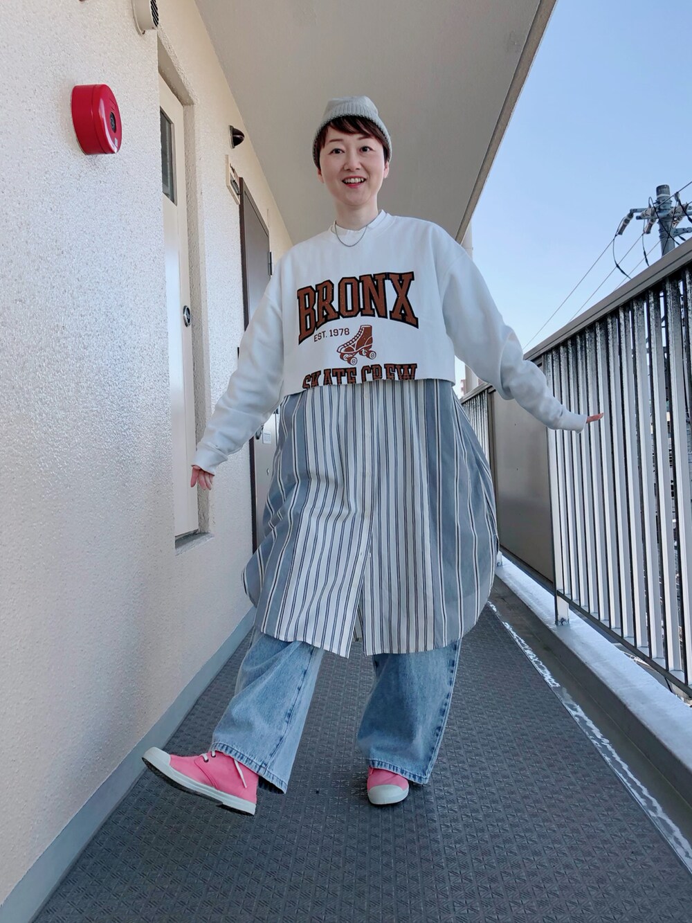 ホワイト系のスウェット、ブルー系のデニムパンツ、ベージュ系のニットキャップ/ビーニーを着用したレディースの春コーディネートの4枚目の写真