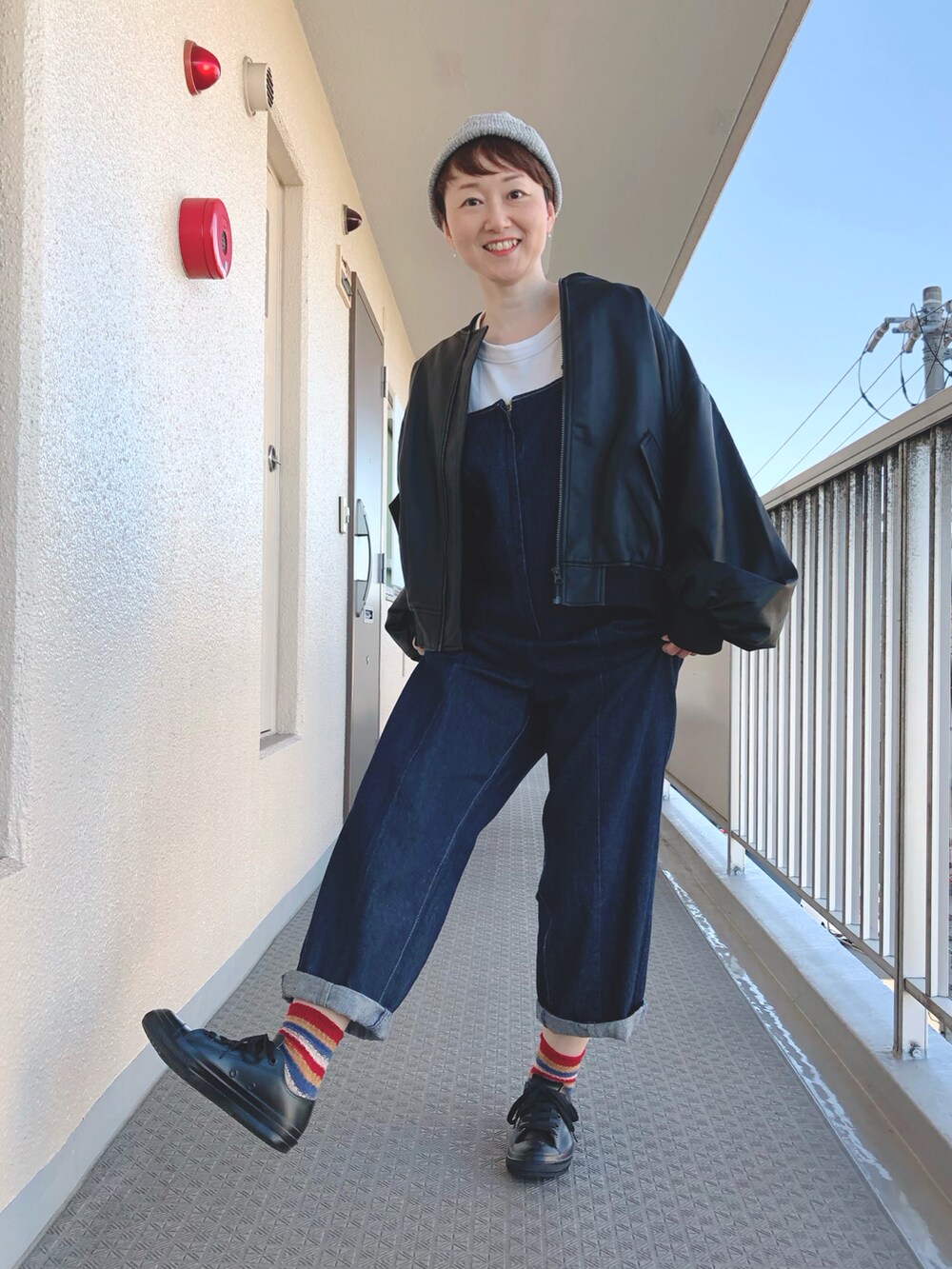 ブラック系のその他アウター、ブルー系のサロペット/オーバーオール、ブラック系のレインシューズを着用したレディースの秋コーディネートの2枚目の写真