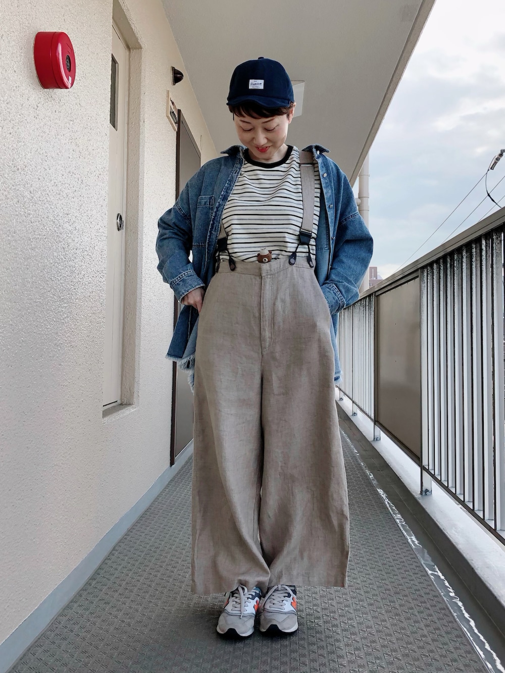 ブラック系のTシャツ/カットソー、ブルー系のシャツ/ブラウス、ベージュ系のサロペット/オーバーオールを着用したレディースの春コーディネートの2枚目の写真