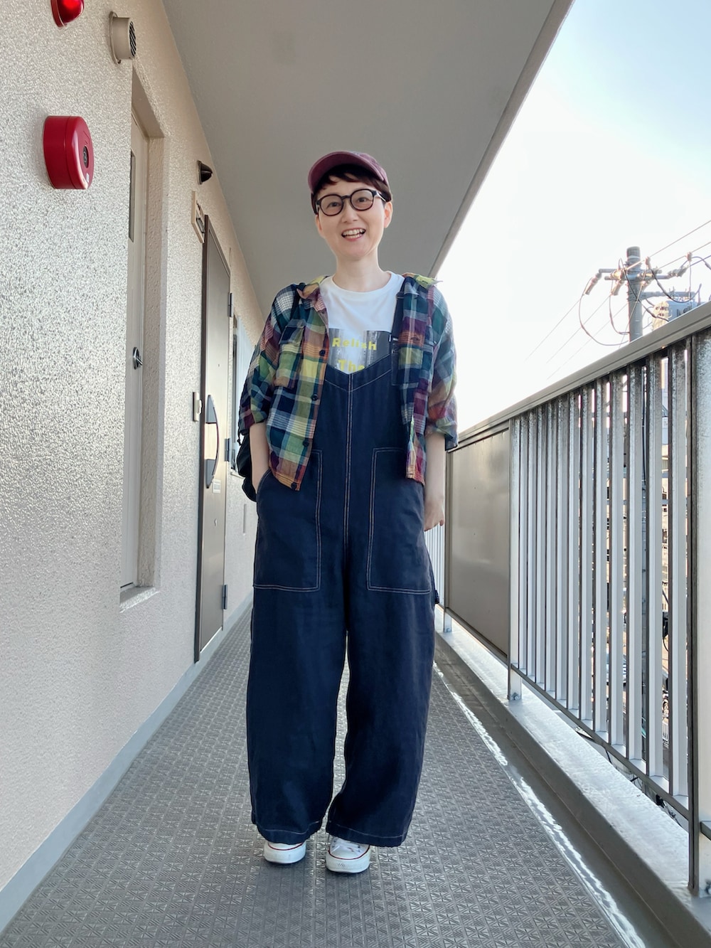 ブルー系のシャツ/ブラウス、ベージュ系のTシャツ/カットソー、ブラック系のサロペット/オーバーオールを着用したレディースの秋コーディネートの2枚目の写真