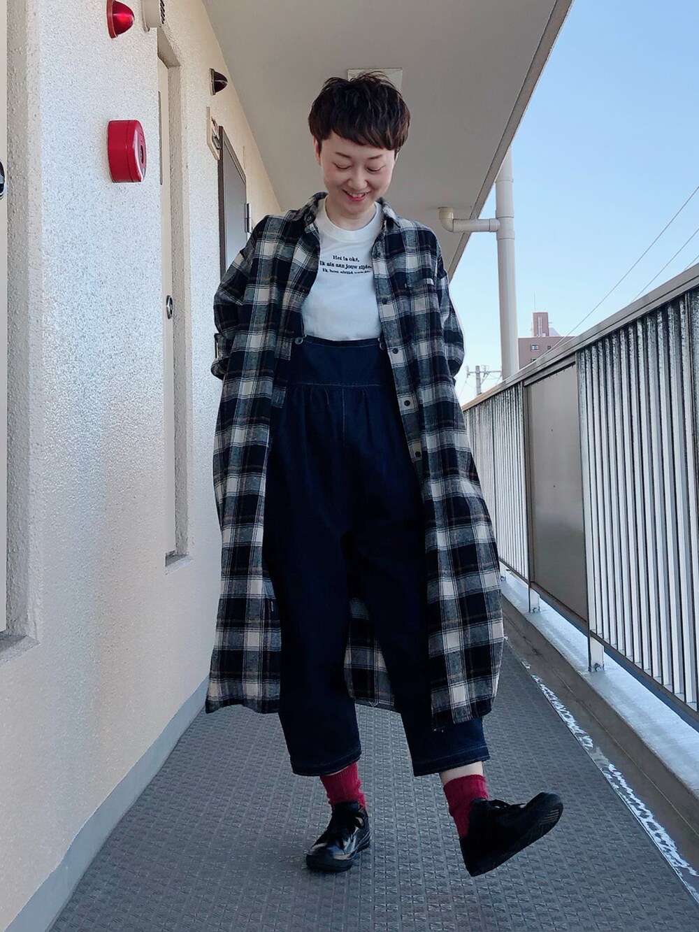 ホワイト系のTシャツ/カットソー、ブルー系のサロペット/オーバーオール、ブラック系のレインシューズを着用したレディースの秋コーディネートの2枚目の写真