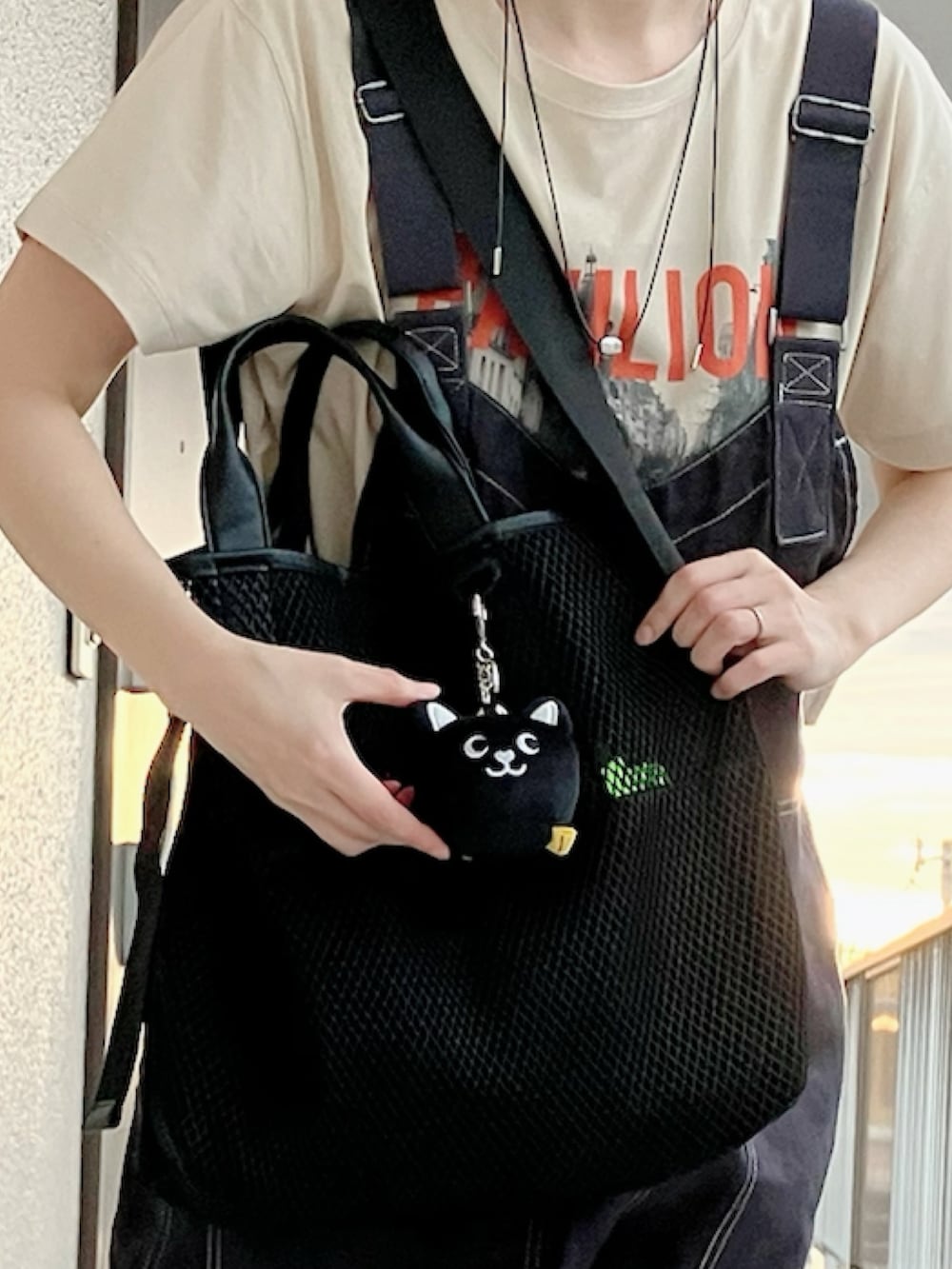 ベージュ系のTシャツ/カットソー、ブラック系のサロペット/オーバーオール、ブラック系のトートバッグを着用したレディースの夏コーディネートの3枚目の写真