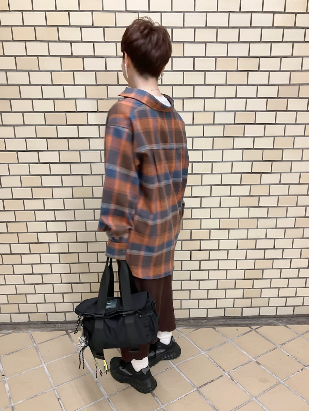 オレンジ系のシャツ/ブラウス、ブラウン系のスカート、ベージュ系のTシャツ/カットソーを着用したレディースの秋コーディネートの3枚目の写真