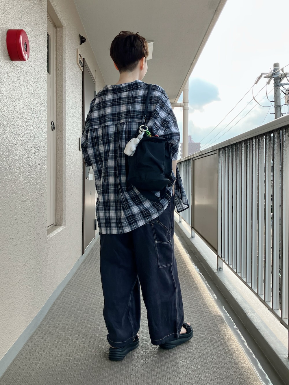 ブラック系のサロペット/オーバーオール、ブラック系のシャツ/ブラウス、ブラック系のサンダルを着用したレディースの夏コーディネートの3枚目の写真