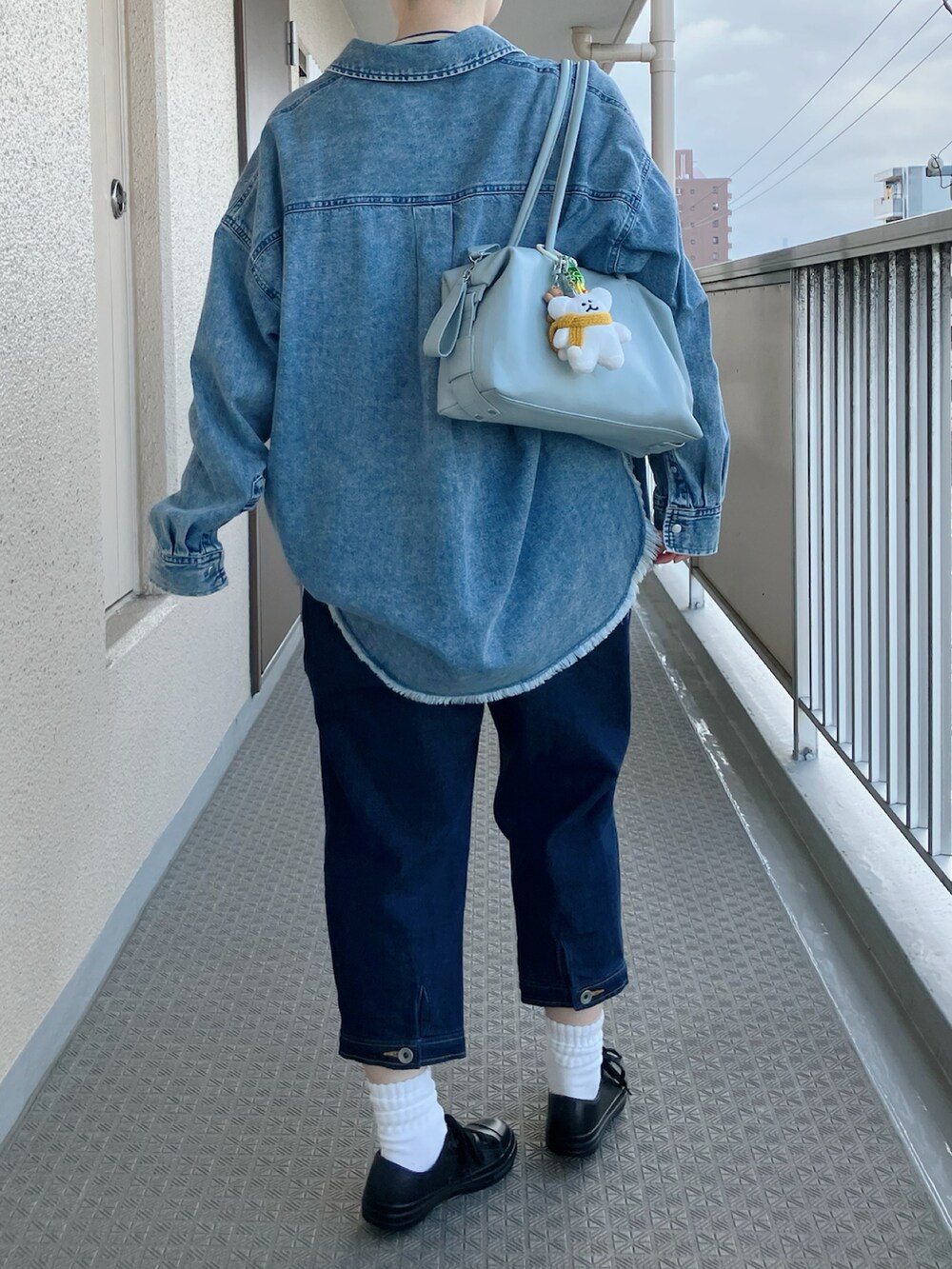 ブルー系のシャツ/ブラウス、ブルー系のサロペット/オーバーオール、ブラック系のレインシューズを着用したレディースの春コーディネートの3枚目の写真