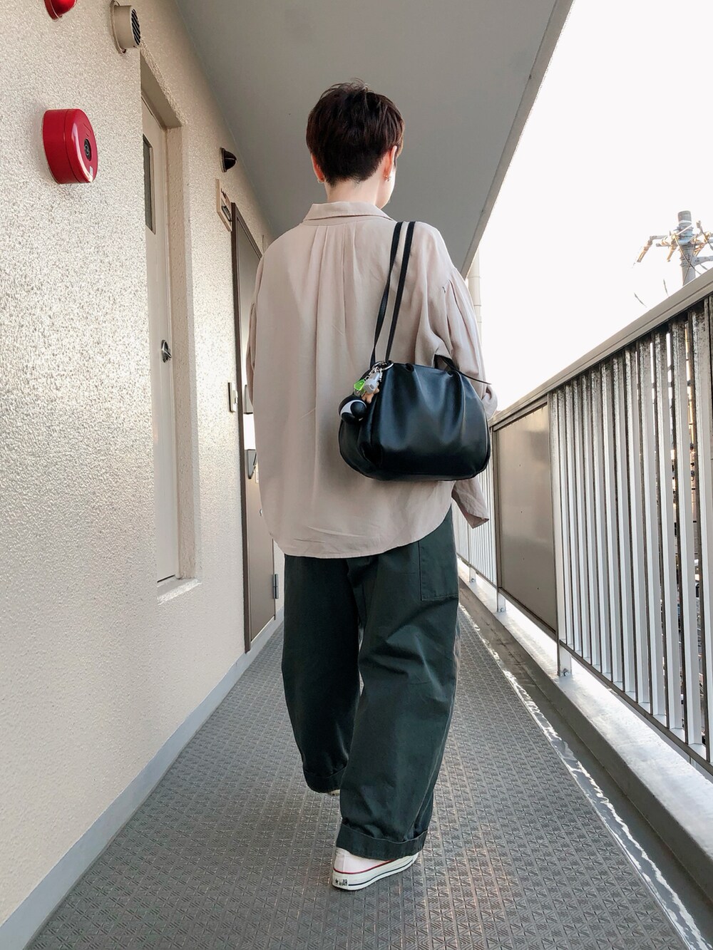 ベージュ系のTシャツ/カットソー、グリーン系のサロペット/オーバーオール、ホワイト系のスニーカーを着用したレディースの秋コーディネートの2枚目の写真