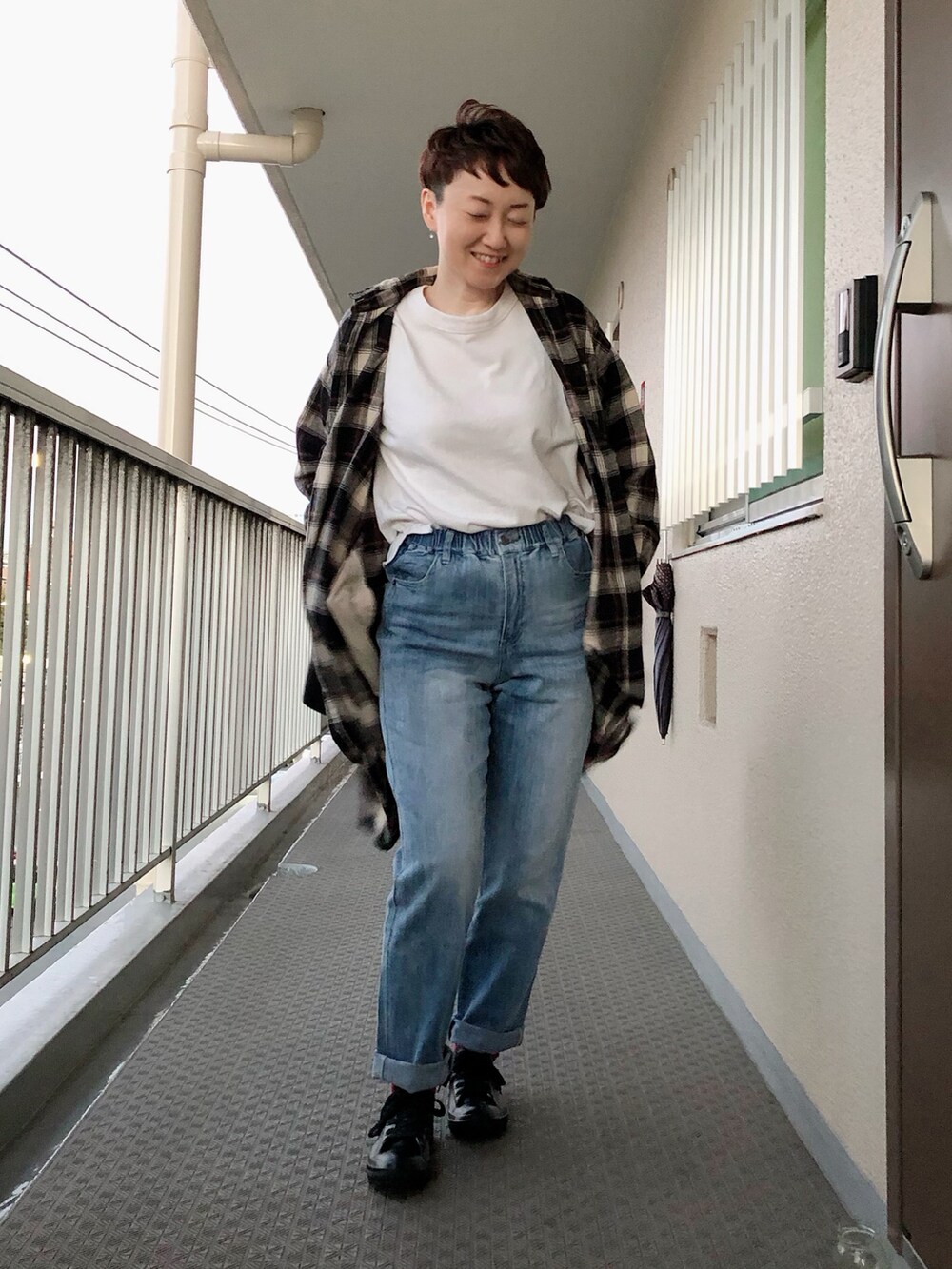 ホワイト系のTシャツ/カットソー、ブラック系のワンピース、ブルー系のデニムパンツを着用したレディースの秋コーディネートの2枚目の写真