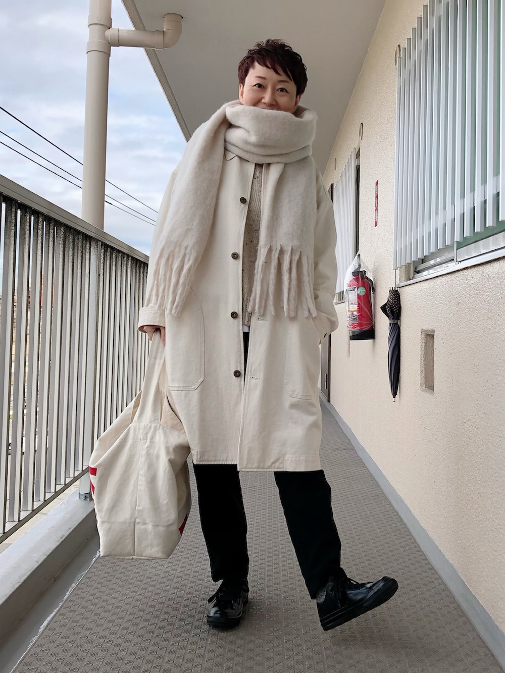 ベージュ系のジャケット/アウター、ベージュ系のニット/セーター、ブラック系のその他パンツを着用したレディースの冬コーディネートの2枚目の写真