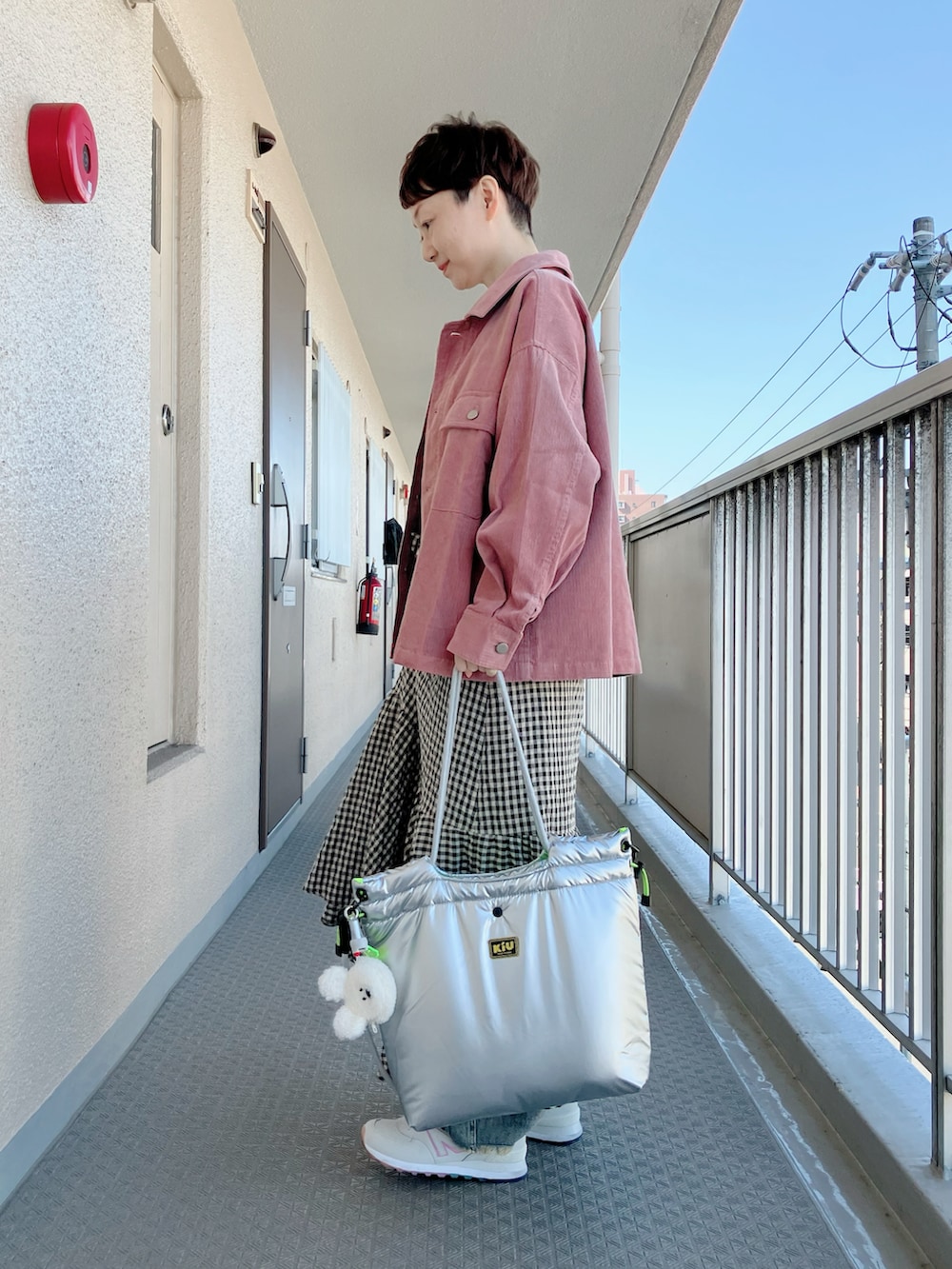 ベージュ系のワンピース、ピンク系のブルゾン、ホワイト系のTシャツ/カットソーを着用したレディースの冬コーディネートの3枚目の写真