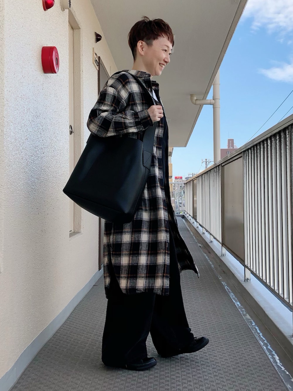 ブラック系のショルダーバッグ、ブラック系のワンピース、ホワイト系のサロペット/オーバーオールを着用したレディースの秋コーディネートの3枚目の写真