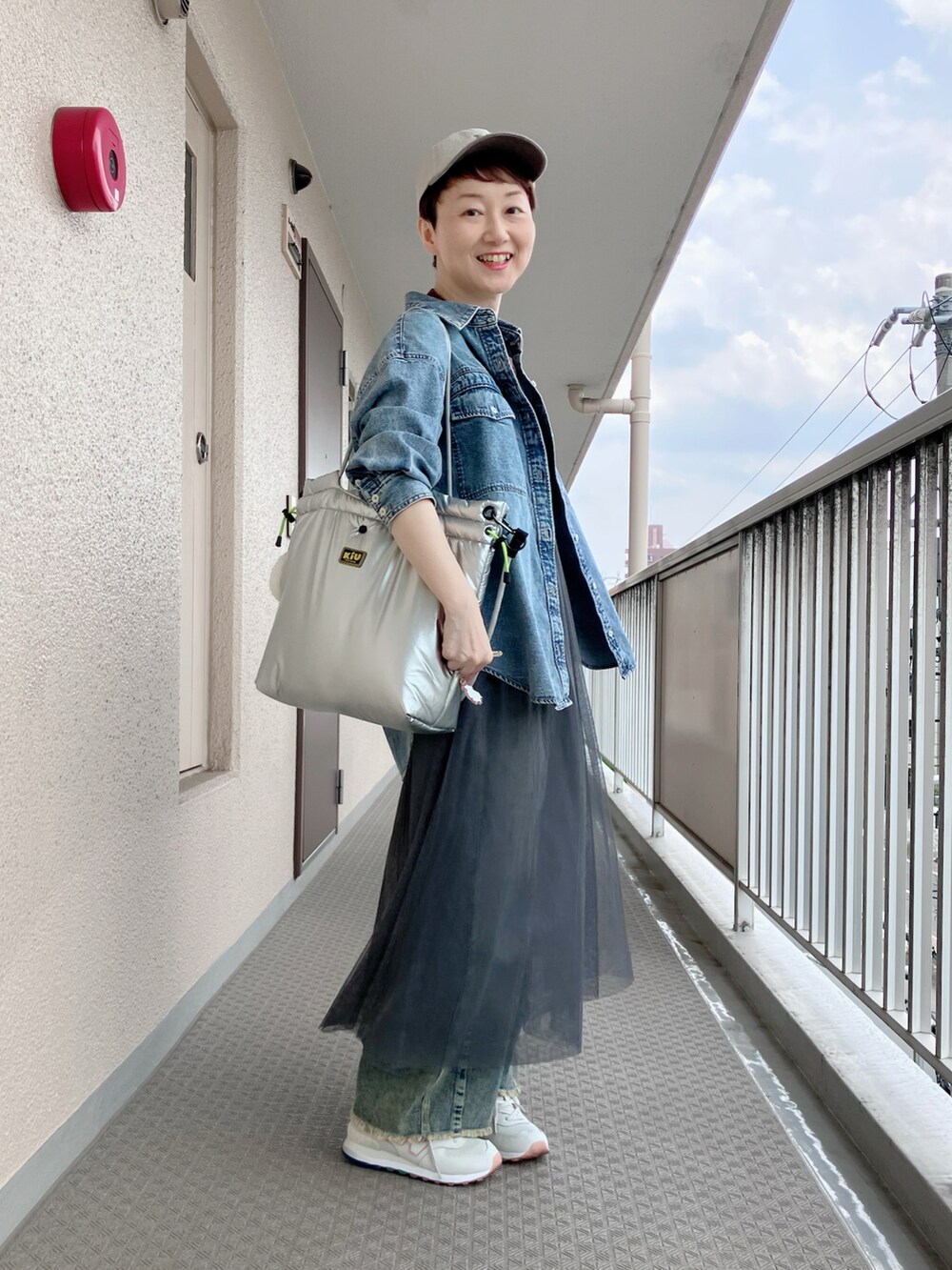 グレー系のワンピース、ブラウン系のTシャツ/カットソー、ブルー系のシャツ/ブラウスを着用したレディースの春コーディネートの2枚目の写真